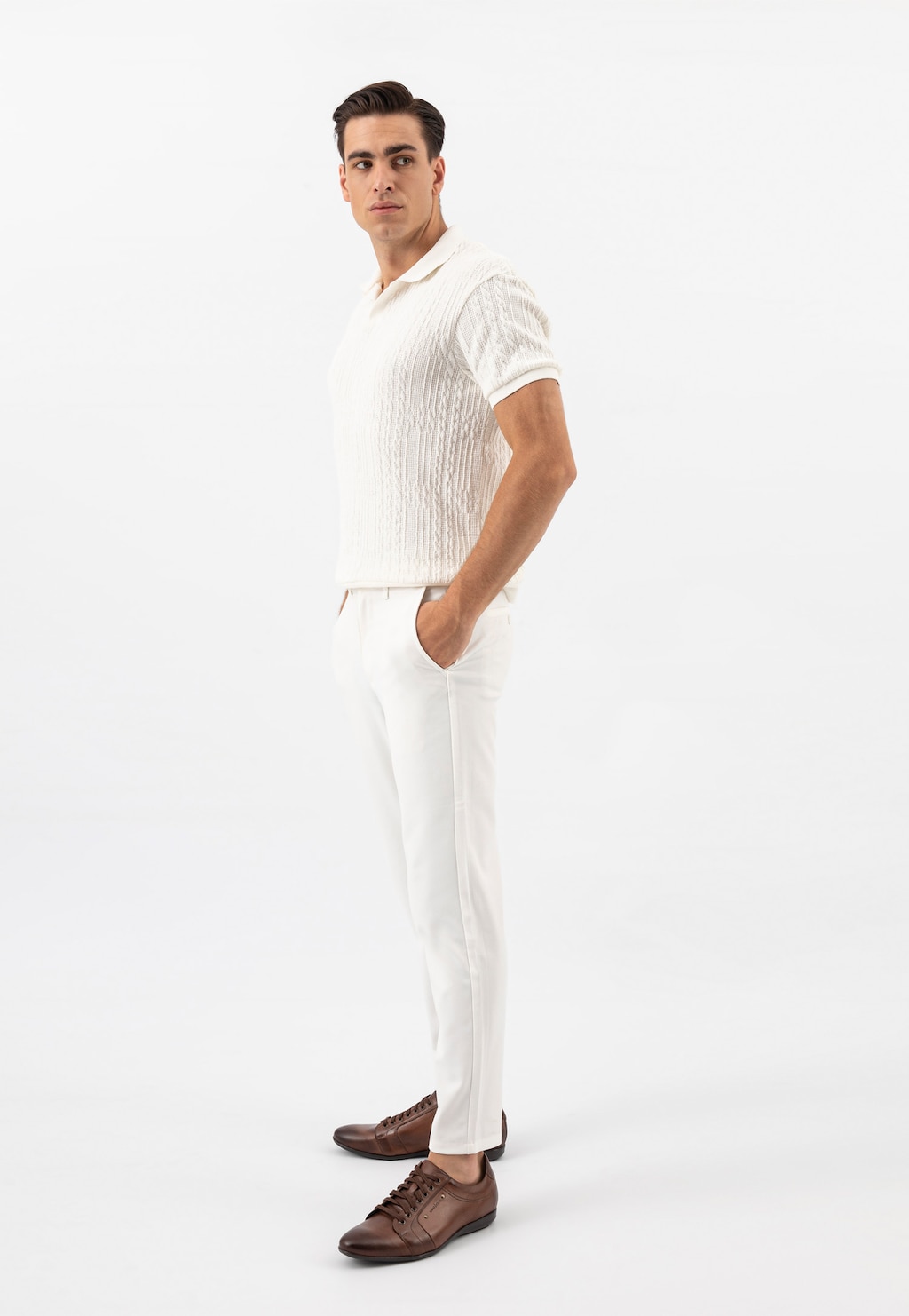 Elegancki strój z brązowymi półbutami męskimi Wojas model 7004-52, które doskonale uzupełniają białą stylizację z dzianinowym polo i spodniami.