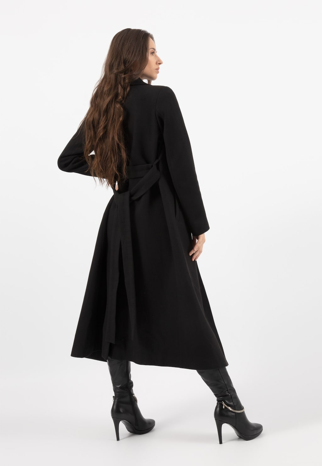 Elegancki czarny płaszcz damski RELAKS R99018-41 widoczny z tyłu, z paskiem w talii, długość midi, prezentowany z czarnymi szpilkami.