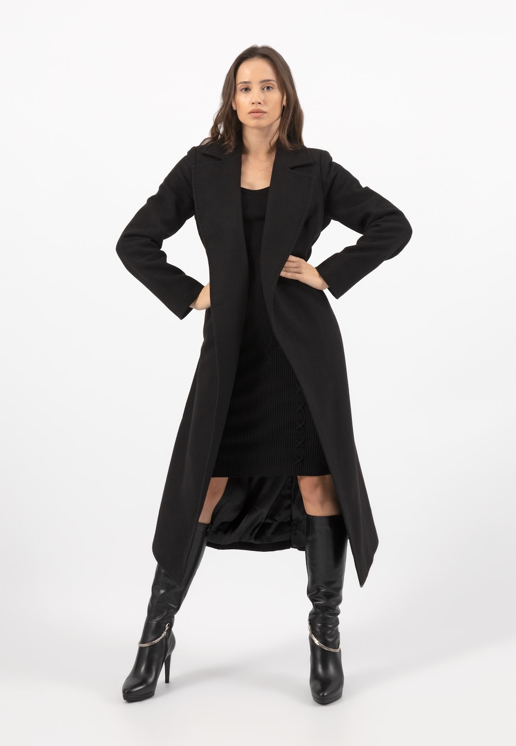 Elegancki czarny płaszcz damski RELAKS model R99018-41 w stylizacji z czarną sukienką i wysokimi kozakami na obcasie. Długi, klasyczny krój płaszcza.