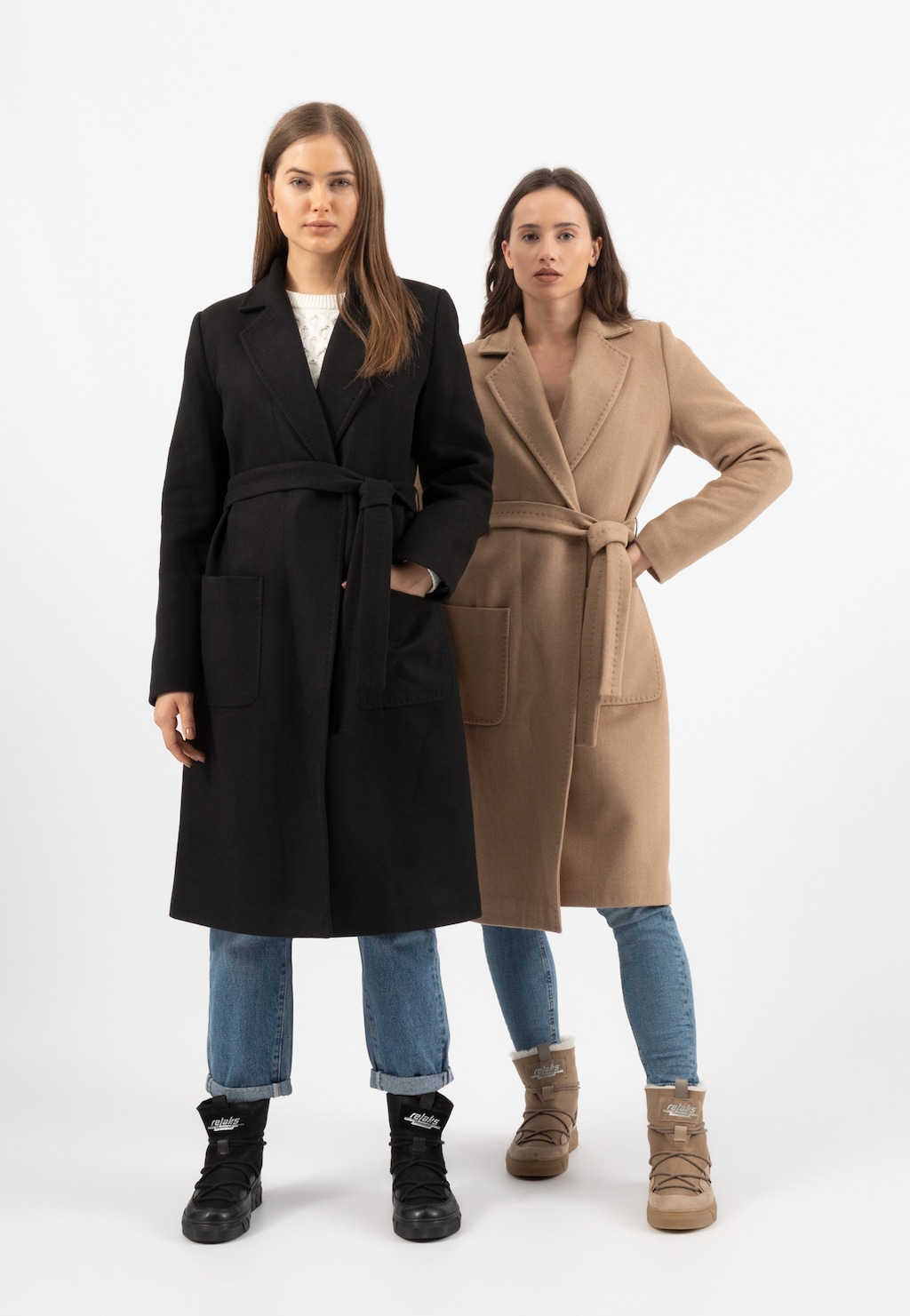 Modelki prezentujące płaszcze w dwóch kolorach - czarnym i beżowym (model RELAKS R99020-44), ubrane w białe swetry i jeansy. Na nogach buty marki Relaks w kolorach dopasowanych do płaszczy.