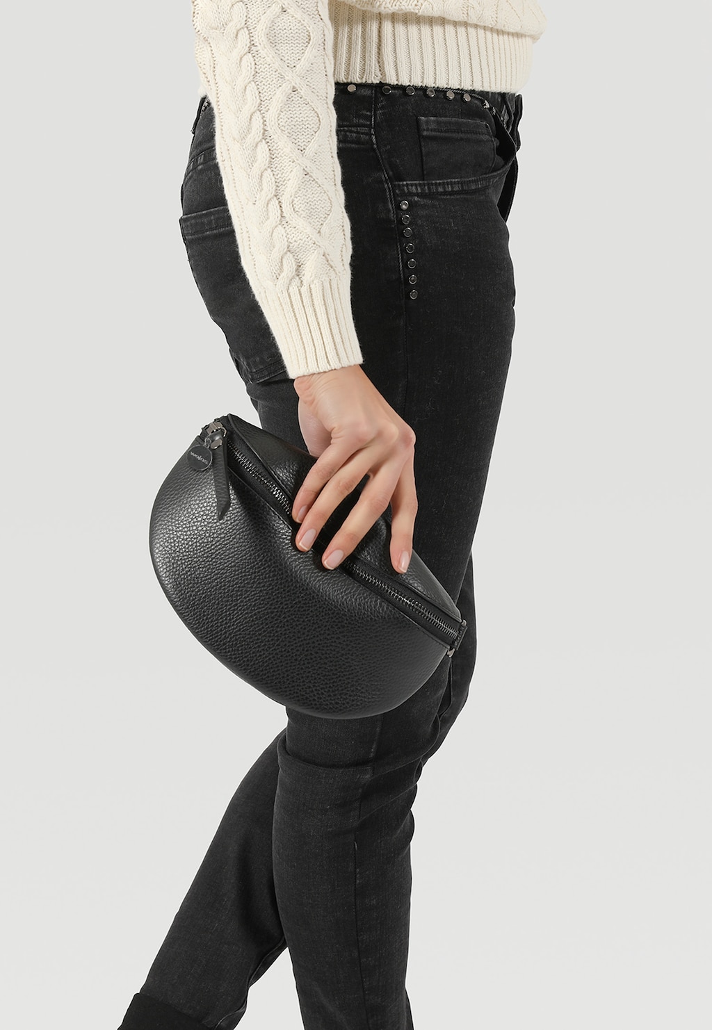 Pojemna czarna nerka Wojas model 80099-51 trzymana w dłoni przez osobę w białym swetrze i czarnych jeansach, pokazująca praktyczny rozmiar i styl torebki.