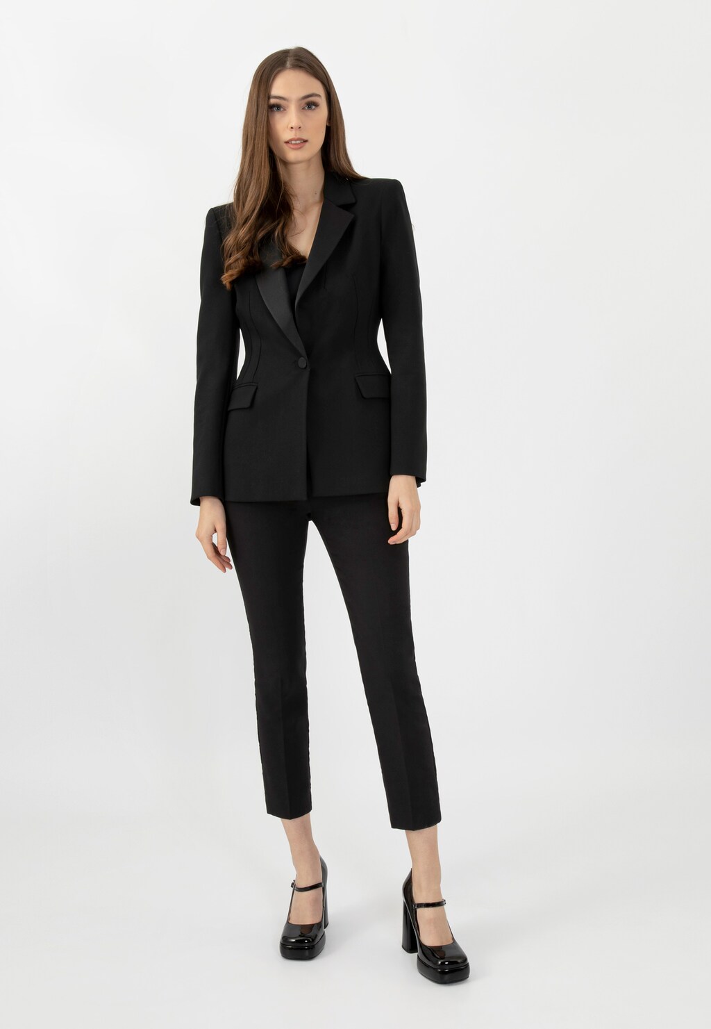 Elegancki czarny garnitur damski z marynarką i spodniami, uzupełniony czarnymi lakierowanymi czółenkami Wojas Mary Jane model 35117-31 na wysokim obcasie.