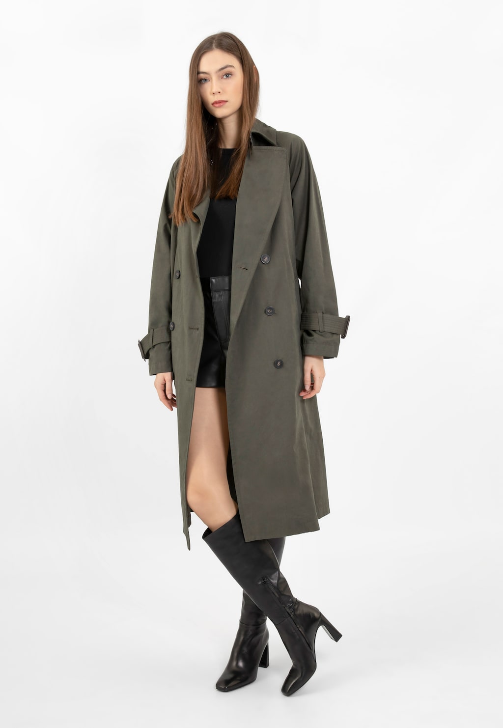 Modelka w oliwkowym płaszczu i czarnych kozakach Wojas 71044-51 ze skóry licowej na słupku. Eleganckie buty sięgają za kolano, doskonale uzupełniając jesienną stylizację.