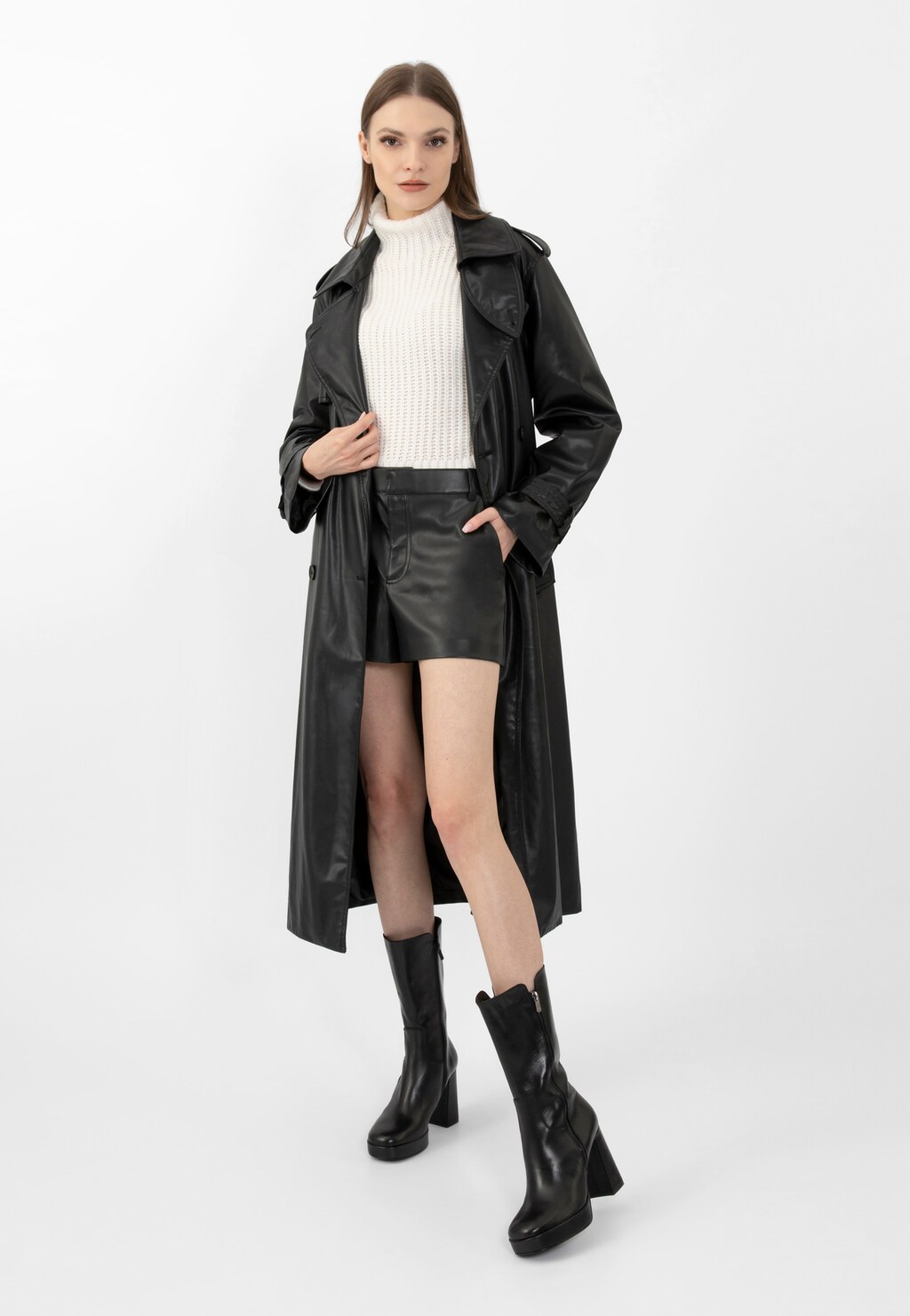 Stylowy strój z czarnymi botkami Wojas model 55215-51 na wysokim obcasie, uzupełniony długim skórzanym płaszczem, białym golfem i skórzaną spódnicą.