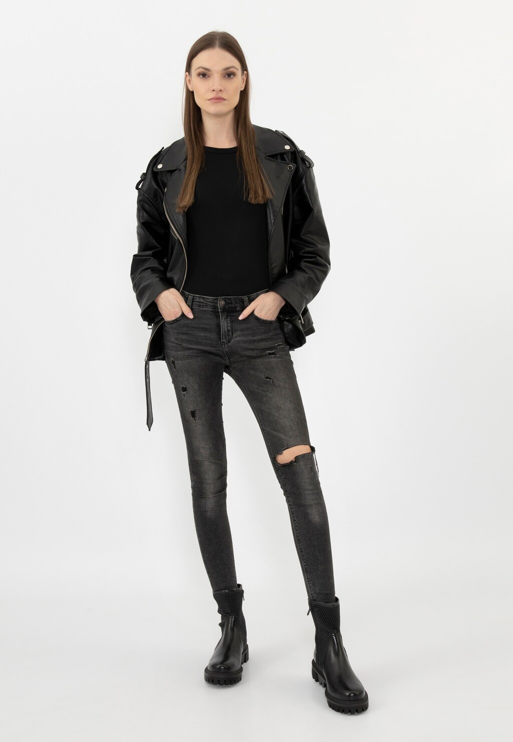 Modelka w stylizacji z czarnymi elastycznymi botkami Wojas 55228-81 zapinanymi na zamek, czarną ramoneską i podartymi jeansami. Buty widoczne z przodu.