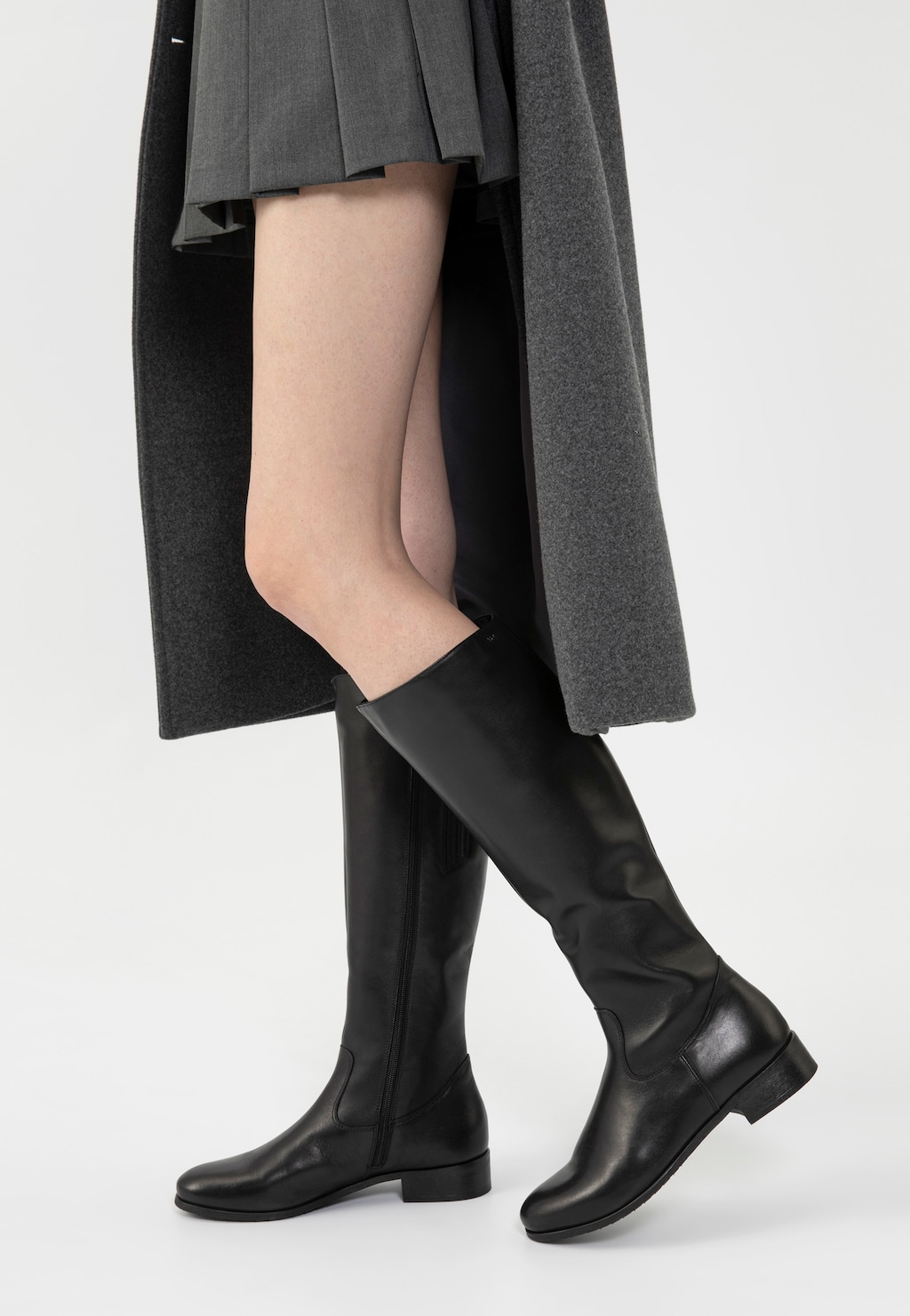 Czarne skórzane kozaki oficerki damskie Wojas model 71015-59, prezentowane na nodze modelki w szarym płaszczu i spódnicy, idealne do eleganckiej stylizacji jesienno-zimowej.