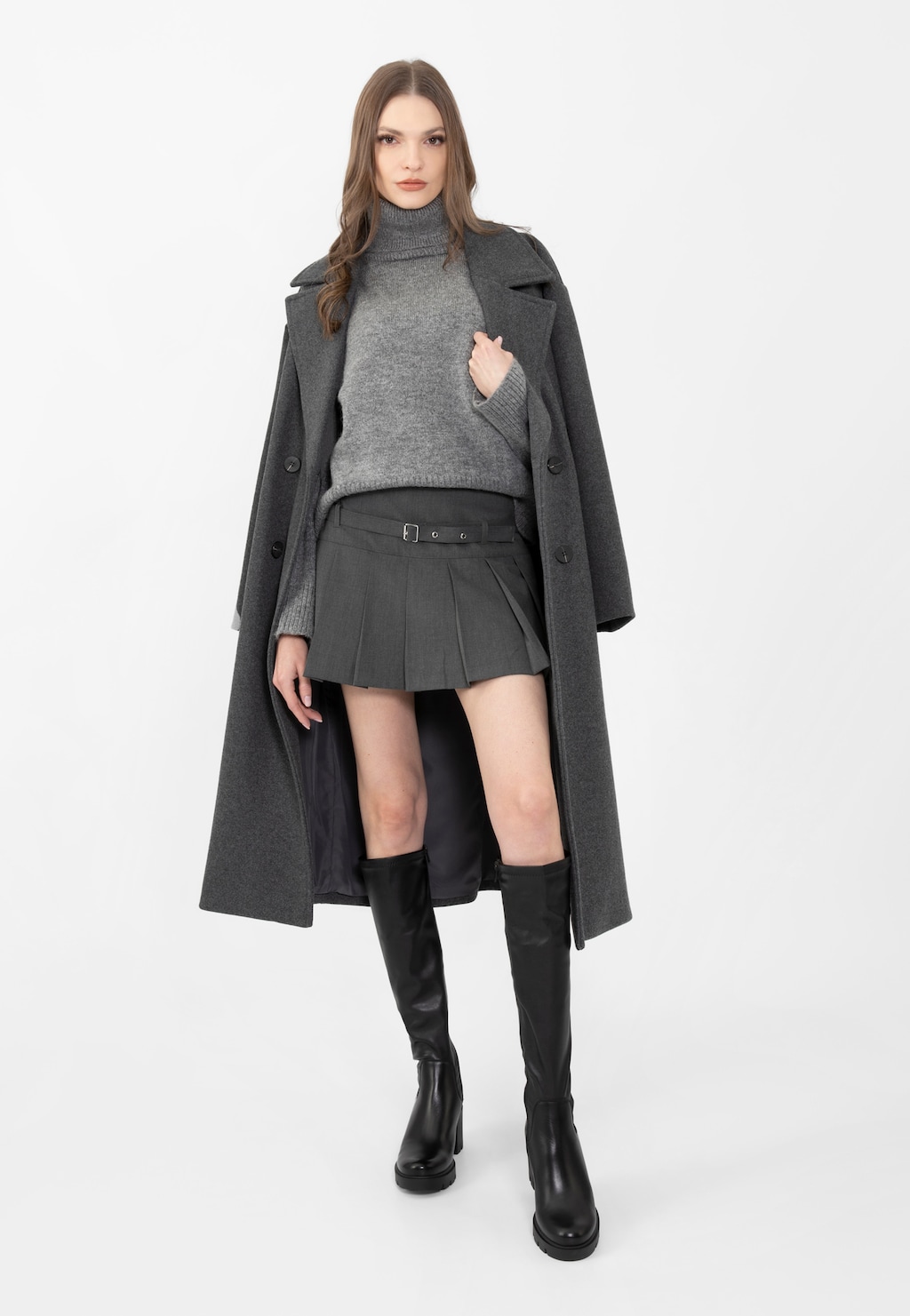 Modelka w eleganckim szarym płaszczu i swetrze, prezentująca czarne skórzane kozaki damskie Wojas model 71025-51 na masywnym słupku, idealne do jesienno-zimowej stylizacji.