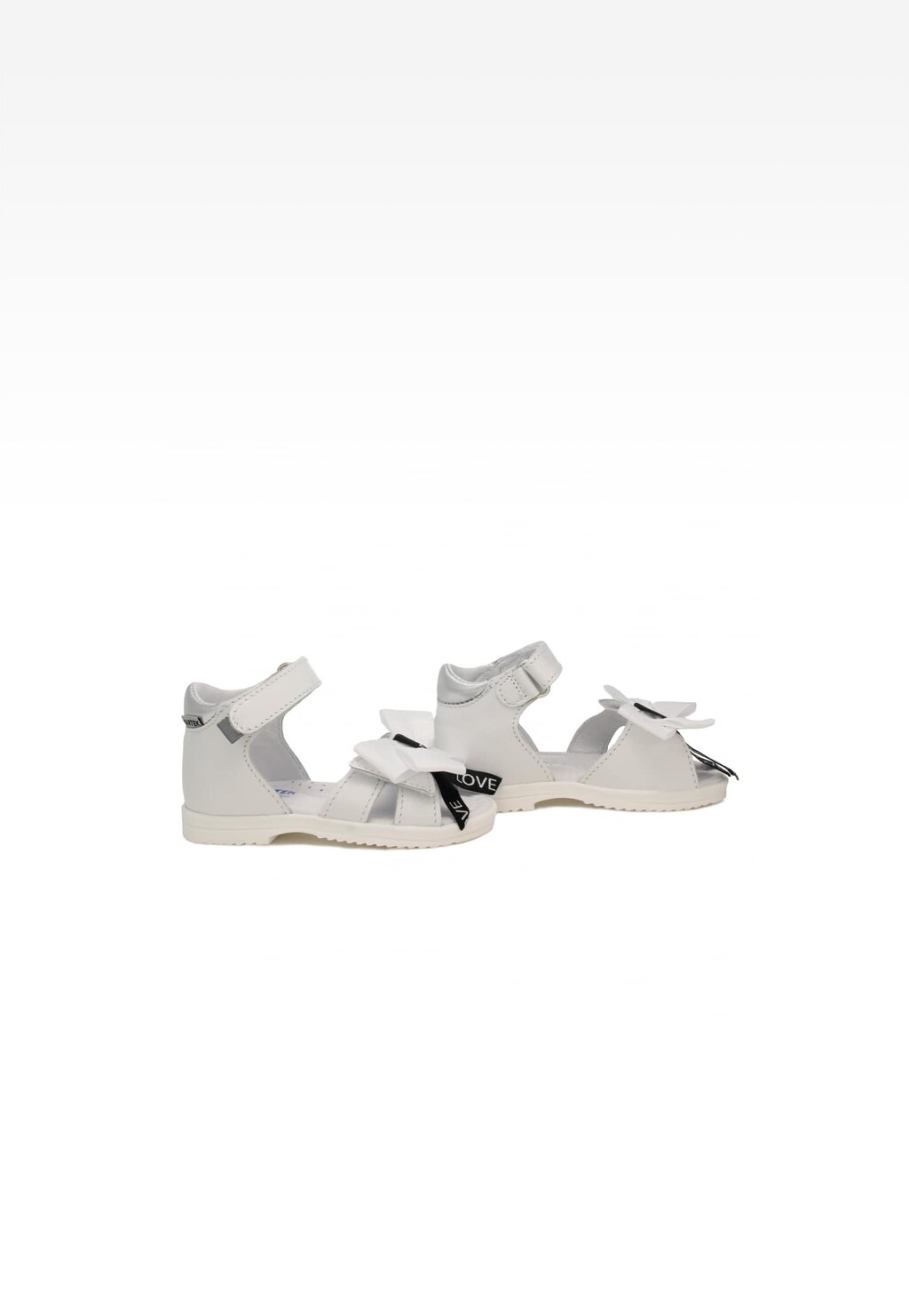 Białe sandały dziewczęce BARTEK 11534002 z ozdobnymi kokardkami, zapinane na rzep, widok z boku pokazujący elegancki design obuwia letniego.