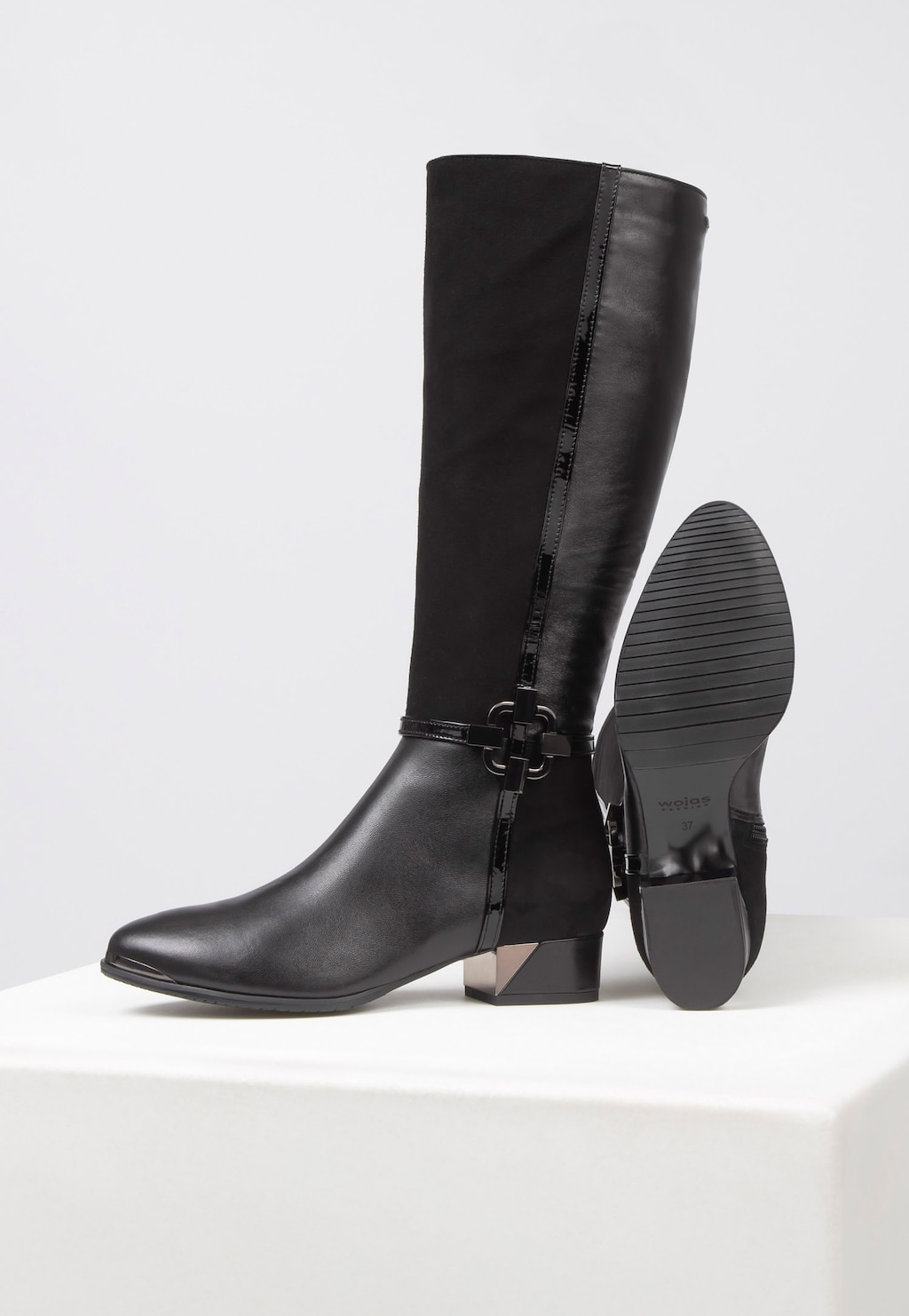 Eleganckie czarne kozaki damskie Wojas PREMIUM 71035-71 z cholewką do kolana, ozdobne zapięcie, widoczna podeszwa z wzorem, niski obcas z metalicznym elementem.