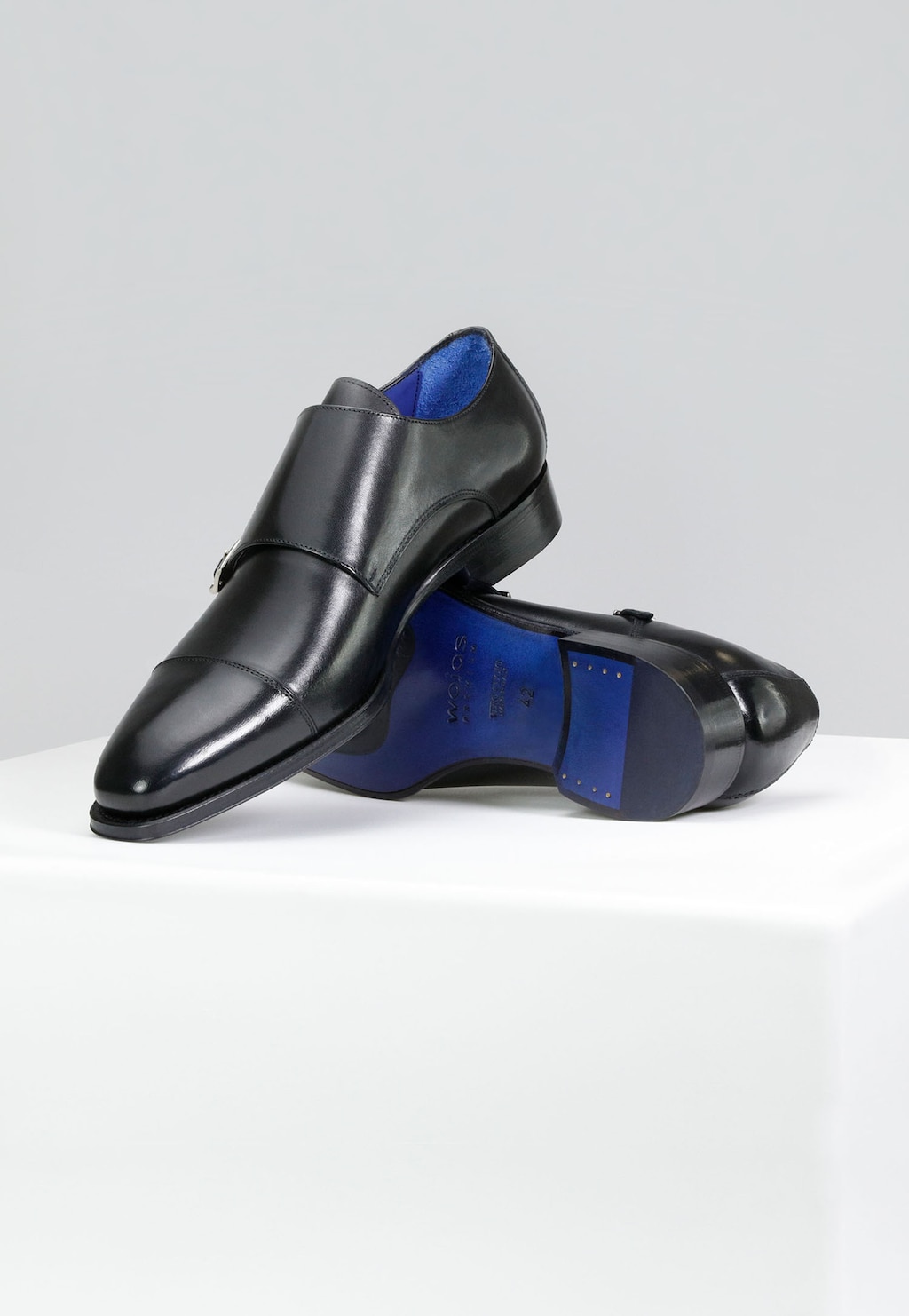 Eleganckie czarne monki Wojas PREMIUM model 10059-51 z dwiema klamrami, prezentowane z boku. Widoczna niebieska wkładka i podeszwa z charakterystycznym wykończeniem.