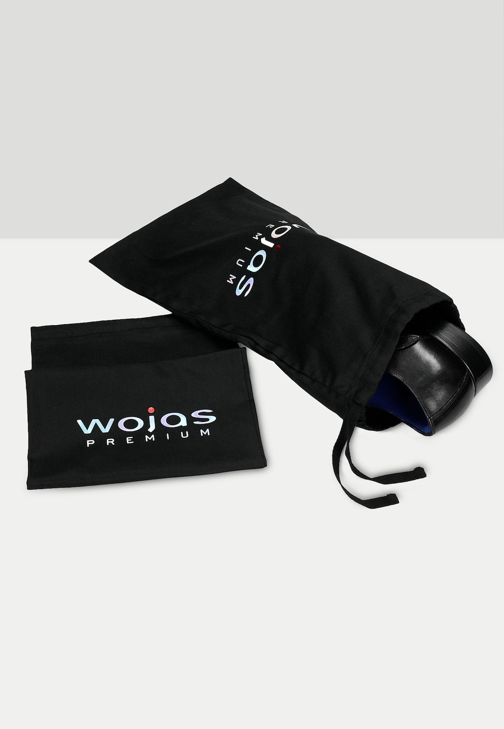 Czarne woreczki ochronne marki Wojas z logo, zawierające eleganckie monki PREMIUM model 10059-51 z dwiema klamrami. Częściowo widoczny but wystaje z woreczka.