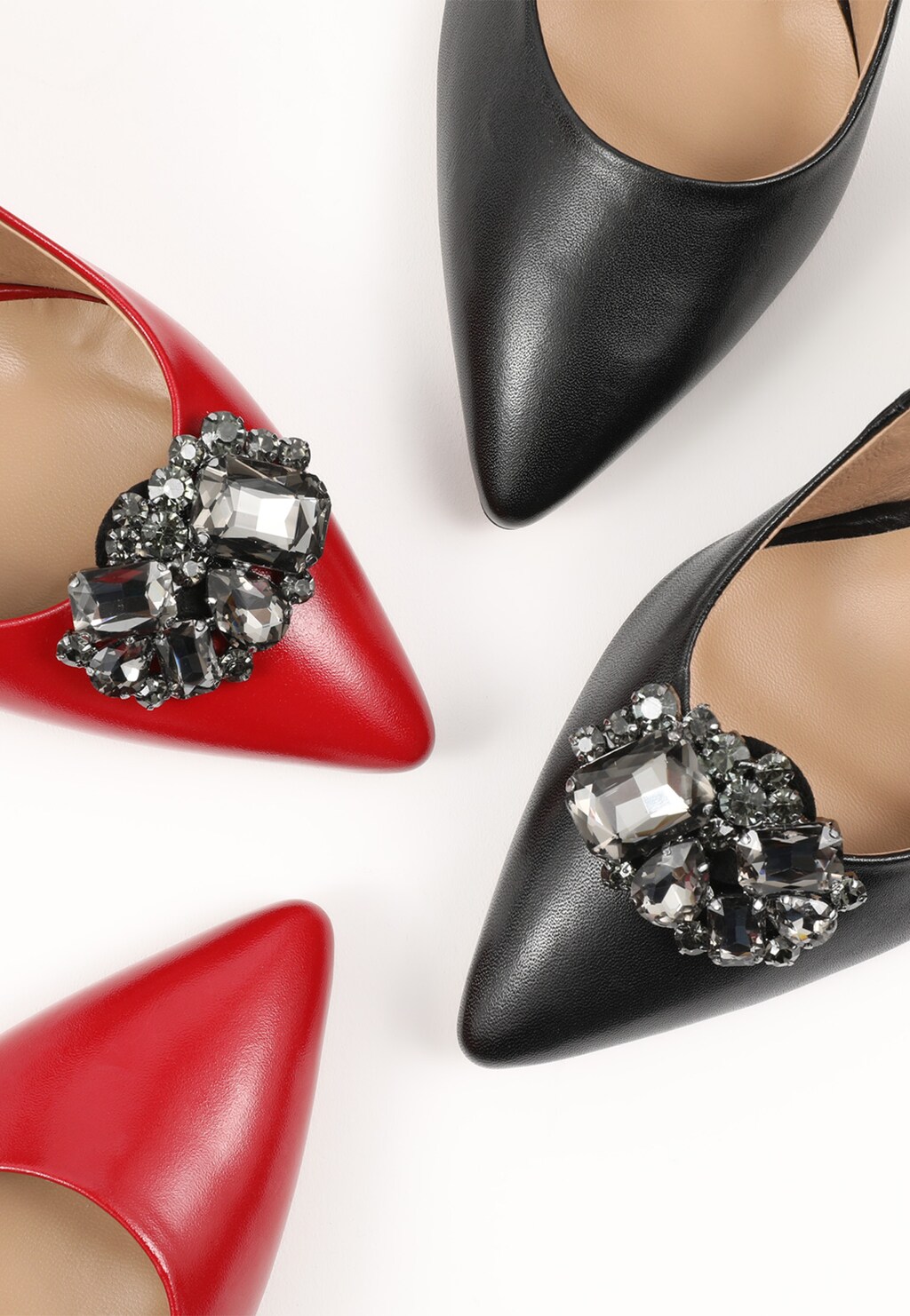Eleganckie ozdoby do obuwia Wojas model 8990-91 z kryształowymi aplikacjami, prezentowane na czerwonych i czarnych szpilkach z ostrymi noskami.