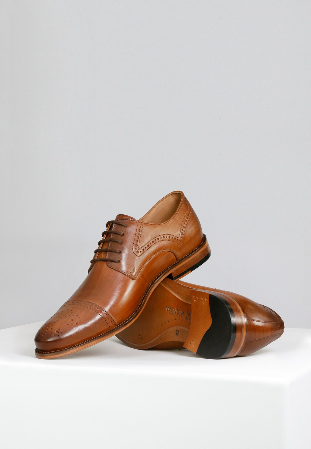 Eleganckie jasnobrązowe półbuty męskie Wojas model 10054-53 z kolekcji PREMIUM. Skórzane obuwie wizytowe z dekoracyjnymi perforacjami na czubku i szwie buta.