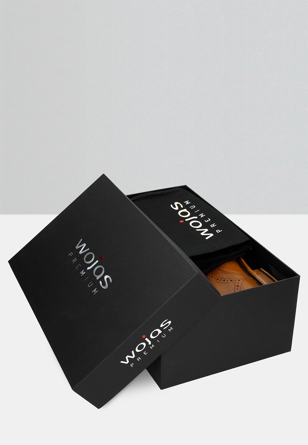 Eleganckie jasnobrązowe półbuty męskie Wojas PREMIUM model 10054-53 w czarnym pudełku prezentowym z logo marki, częściowo widoczne.