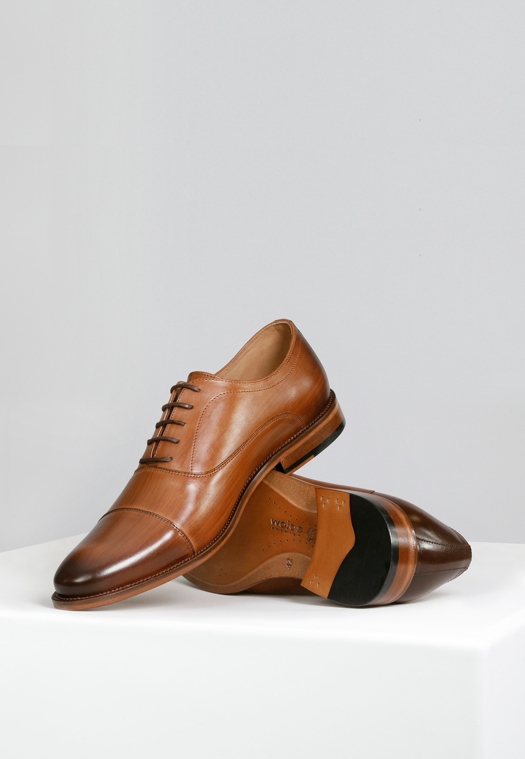 Eleganckie brązowe półbuty Wojas PREMIUM model 10053-53 ze skórzaną podeszwą, pokazane z boku i od spodu, z widocznym szlachetnym wykończeniem i klasycznym systemem sznurowania.