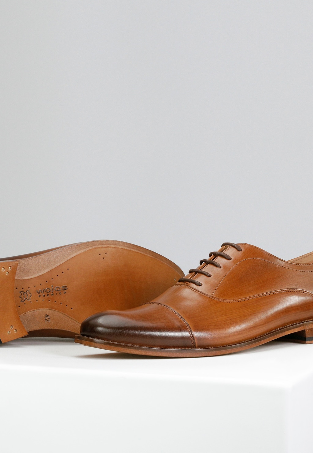 Eleganckie brązowe półbuty Wojas PREMIUM model 10053-53 ze skórzaną podeszwą. Widoczna para butów wizytowych z charakterystycznym czubkiem i sznurowaniem, wykonana z wysokiej jakości skóry.
