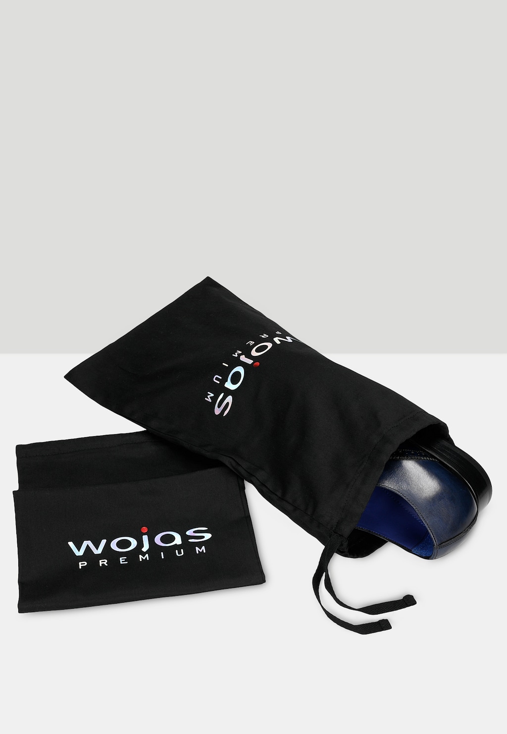 Granatowe półbuty oxford Wojas PREMIUM 10060-56 widoczne częściowo w czarnym ochronnym woreczku z logo marki, obok leży dodatkowy woreczek z napisem Wojas PREMIUM.