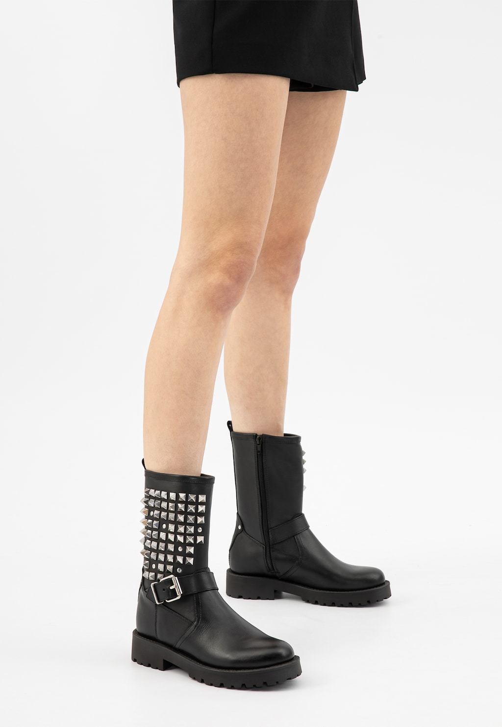 Czarne skórzane bikery damskie Wojas model 55250-51 z charakterystycznymi srebrnymi ćwiekami na cholewce i klamrą, prezentowane na nogach w krótkiej czarnej spódnicy.