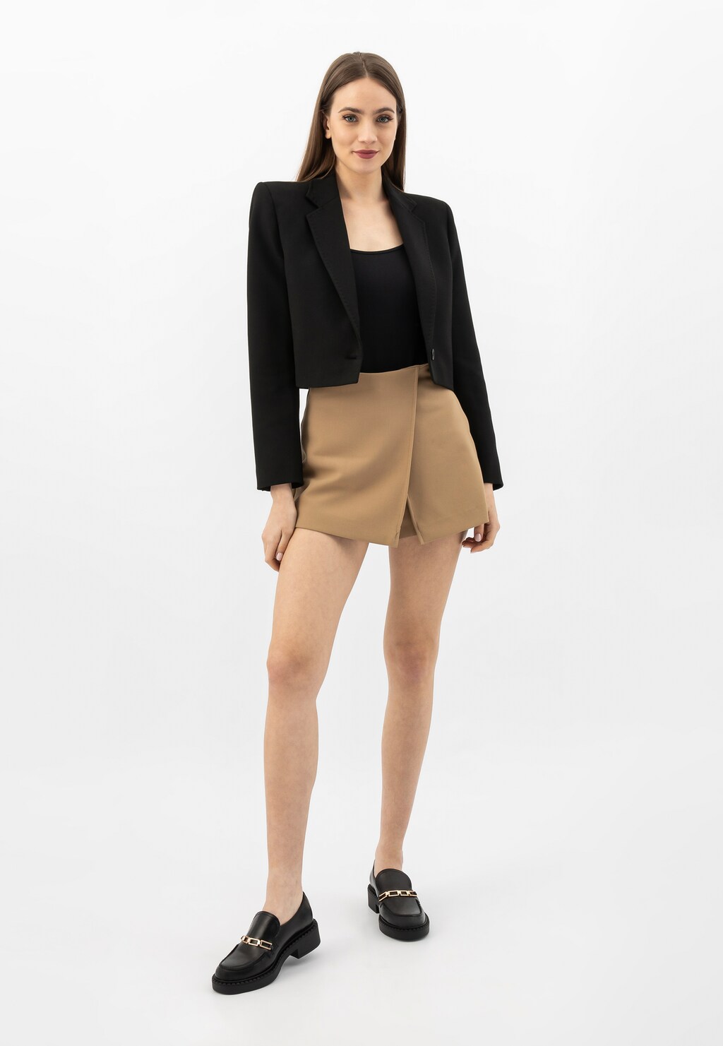 Elegancka stylizacja z czarnymi mokasynami Wojas model 46240-31 ze skóry florentic ze złotą ozdobą, zestawiona z czarnym żakietem, topem i beżową spódnicą.