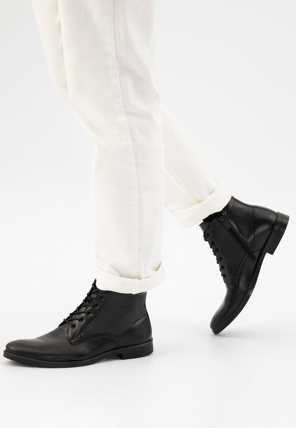 Czarne eleganckie trzewiki męskie Wojas model 24055-51 ze skóry licowej, zapinane na sznurówki, prezentowane na nogach w białych spodniach.