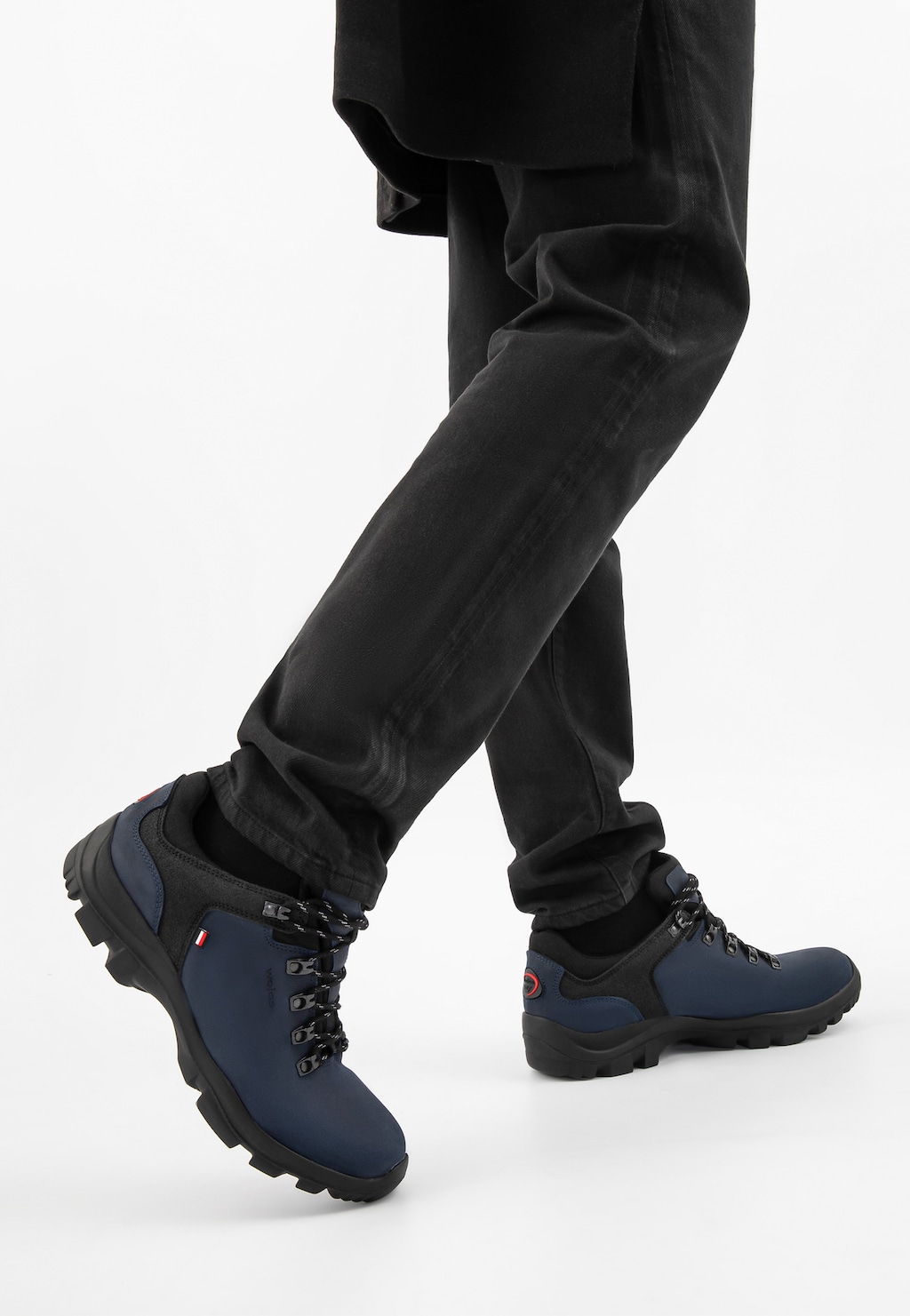 Granatowo-czarne trekkingi męskie Wojas 9377-80 z dzianiną dystansową na nogach mężczyzny w czarnych spodniach, ukazane z bocznej perspektywy.