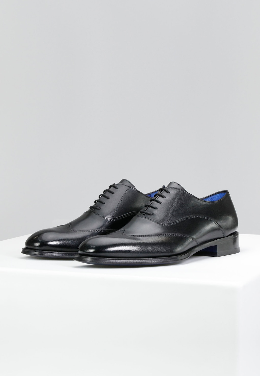 Eleganckie czarne półbuty męskie Wojas model 10058-51 z linii PREMIUM ze skórzaną podeszwą i niebieskim wykończeniem wnętrza, pokazane z boku w parze.