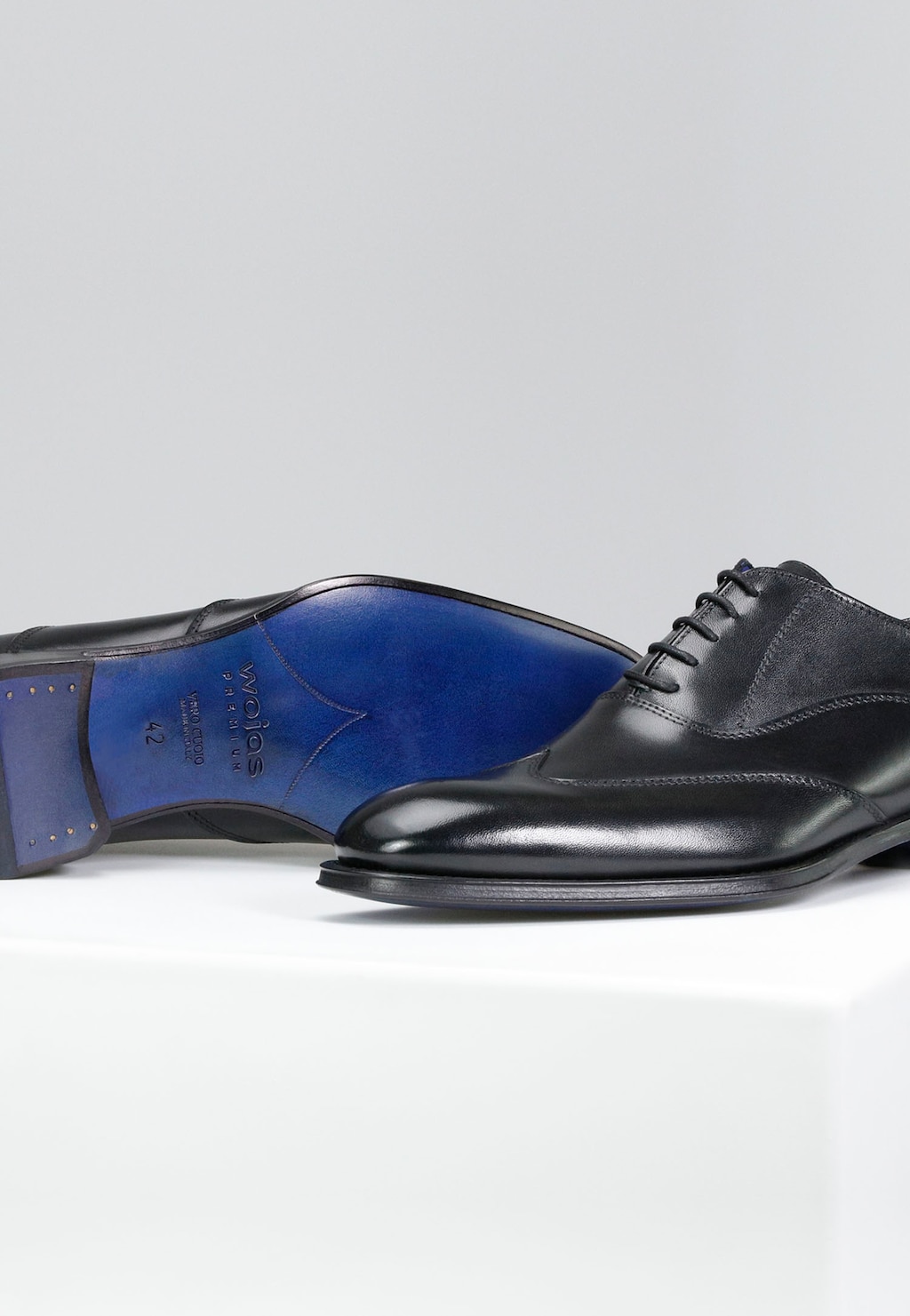 Eleganckie czarne półbuty męskie Wojas model 10058-51 z linii PREMIUM z charakterystyczną niebieską podeszwą skórzaną, widoczne z profilu ukazujące klasyczny oksfordzki krój.