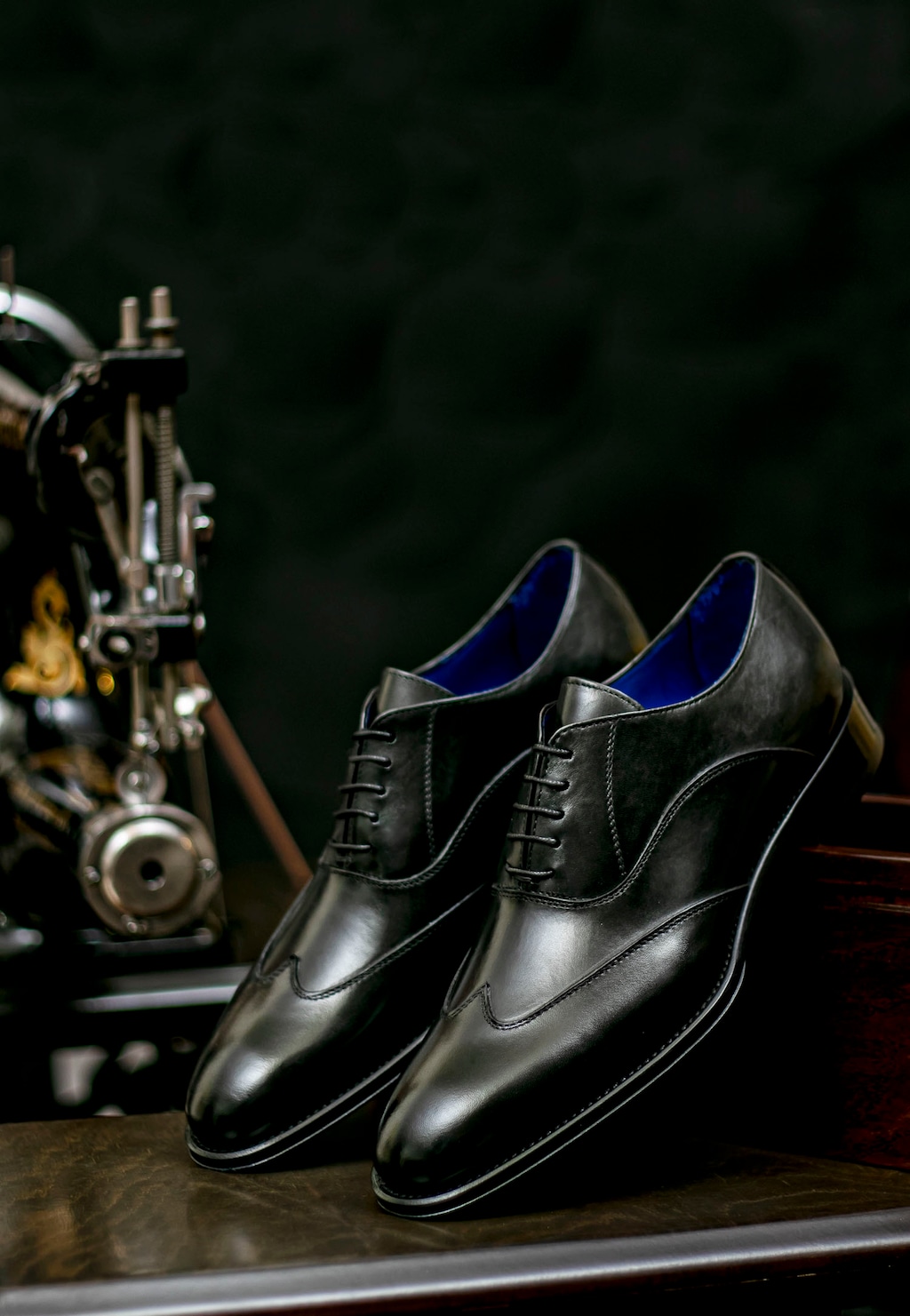 Eleganckie czarne półbuty męskie Wojas PREMIUM 10058-51 ze skórzaną podeszwą, widoczne z niebieskim wykończeniem wnętrza, obok instrumentu muzycznego.