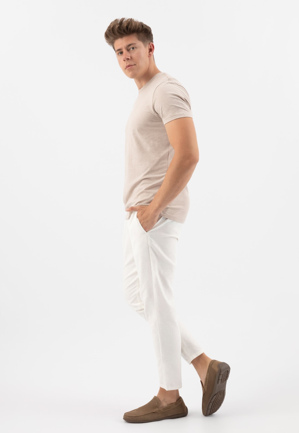 Model w beżowej koszulce i białych spodniach prezentujący beżowe mokasyny męskie Wojas 10103-24 z perforowaną skórą, ukazane z boku.