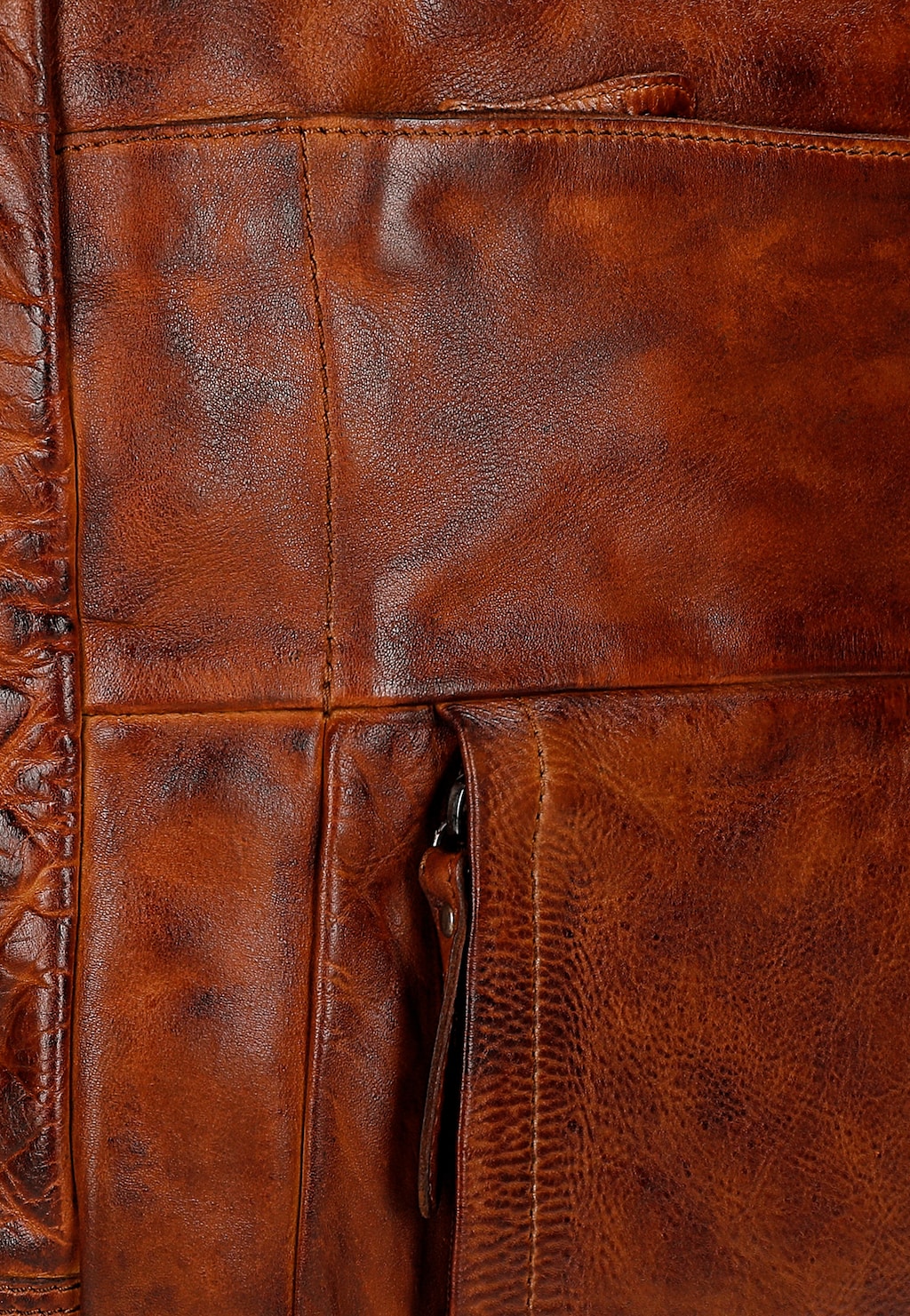 Zbliżenie na brązową skórę licową plecaka-torby Wojas 80360-53. Widoczne eleganckie przeszycia i fragment kieszeni, ukazujące wysoką jakość wykonania i naturalną fakturę skóry.