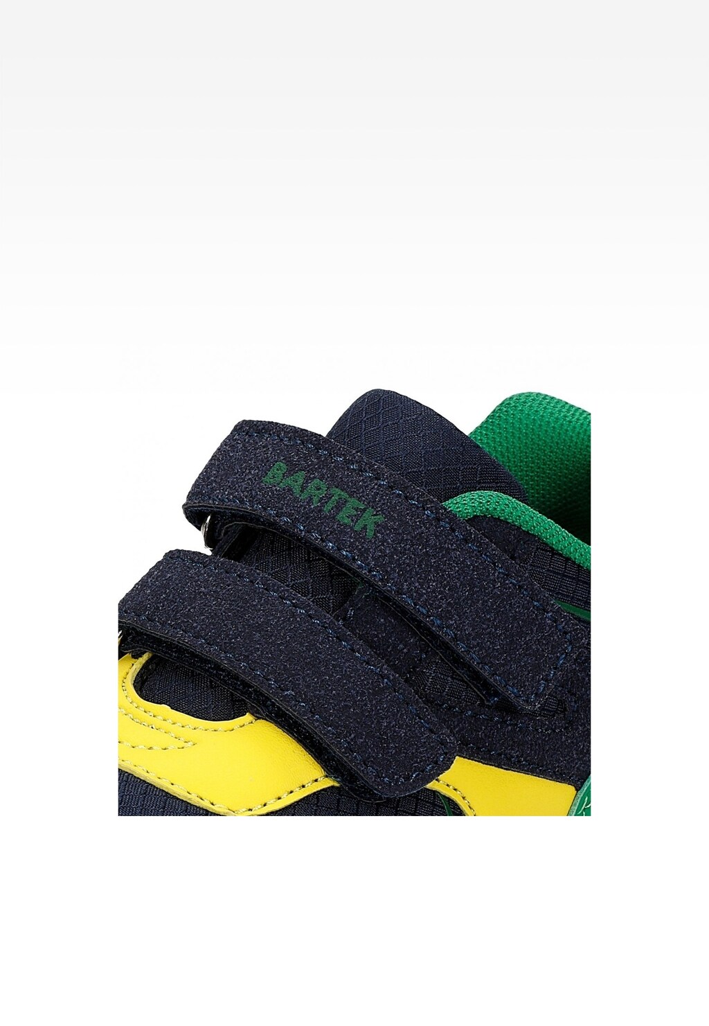 Zbliżenie na granatowe zapięcia rzepowe półbutów Bartek 11043004 dla chłopców, z widocznym zielonym wykończeniem kołnierza oraz żółtymi elementami na cholewce.
