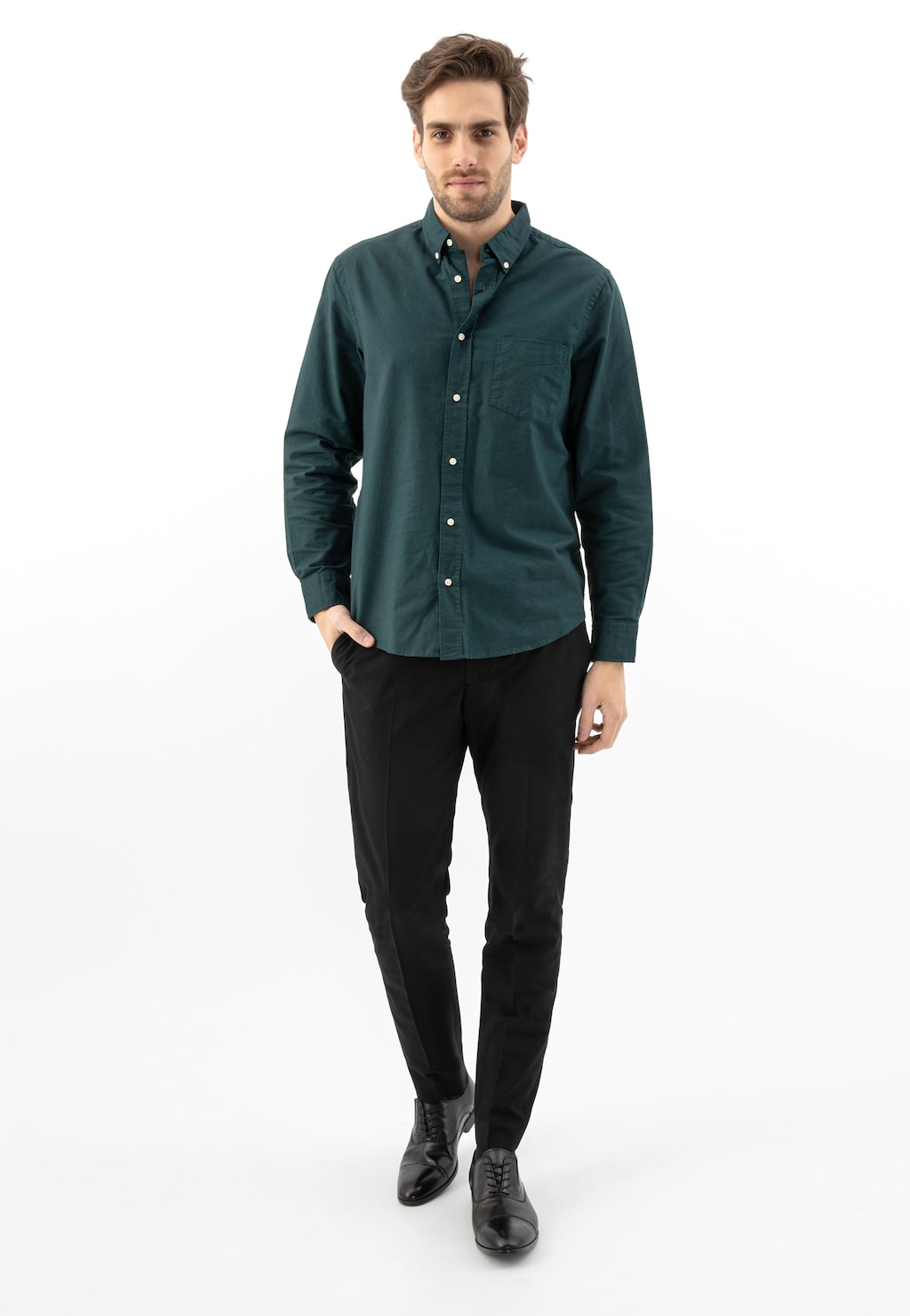 Model w eleganckiej stylizacji z ciemnozieloną koszulą i czarnymi spodniami, prezentujący czarne półbuty męskie Wojas quarter brogue model 10165-51.