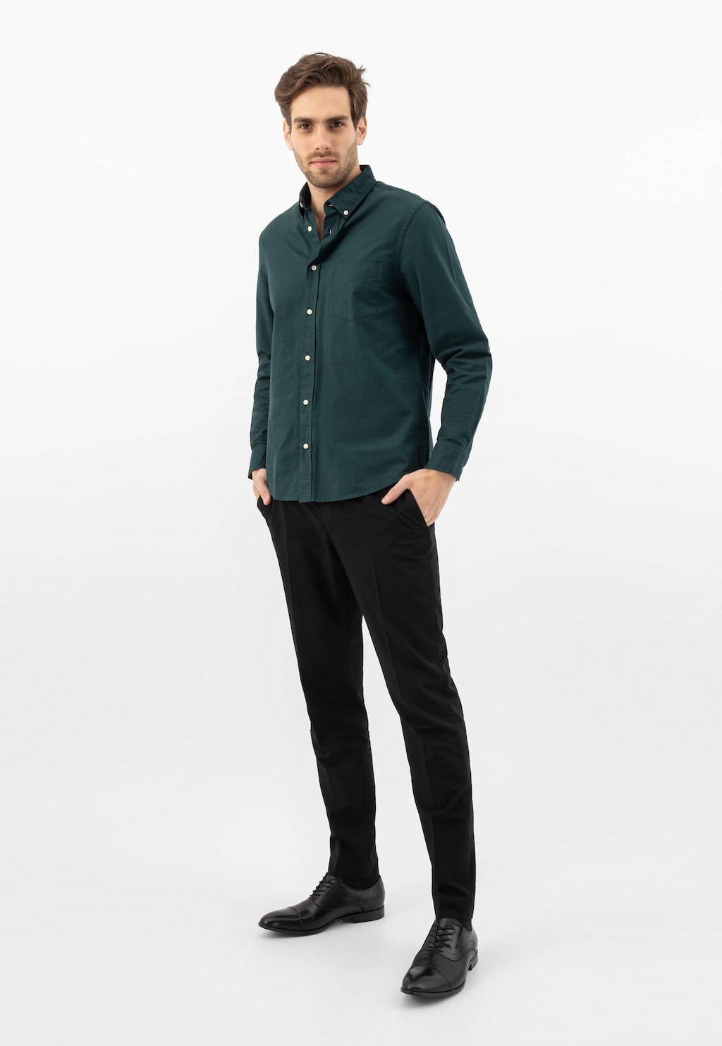 Model w ciemnozielonej koszuli i czarnych spodniach, prezentujący eleganckie czarne półbuty męskie Wojas model 10165-51 typu quarter brogue.