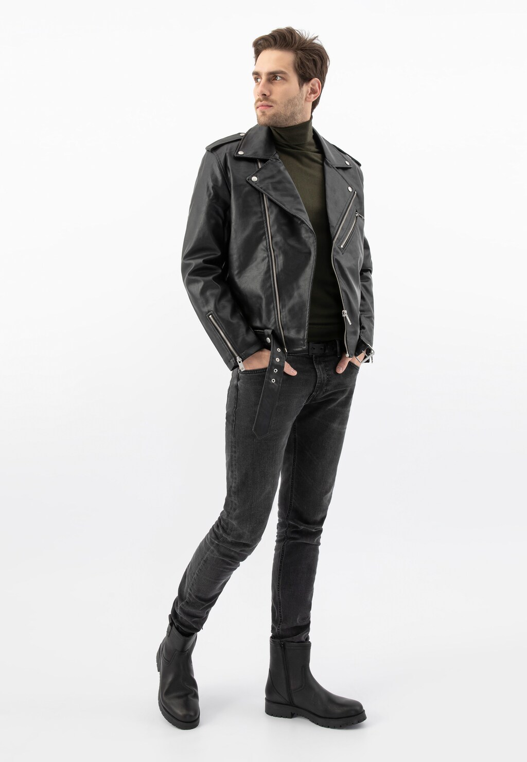 Model w skórzanej kurtce motocyklowej i ciemnych jeansach prezentuje czarne męskie botki Wojas model 20028-51 z bocznym zamkiem, idealne do miejskich stylizacji.