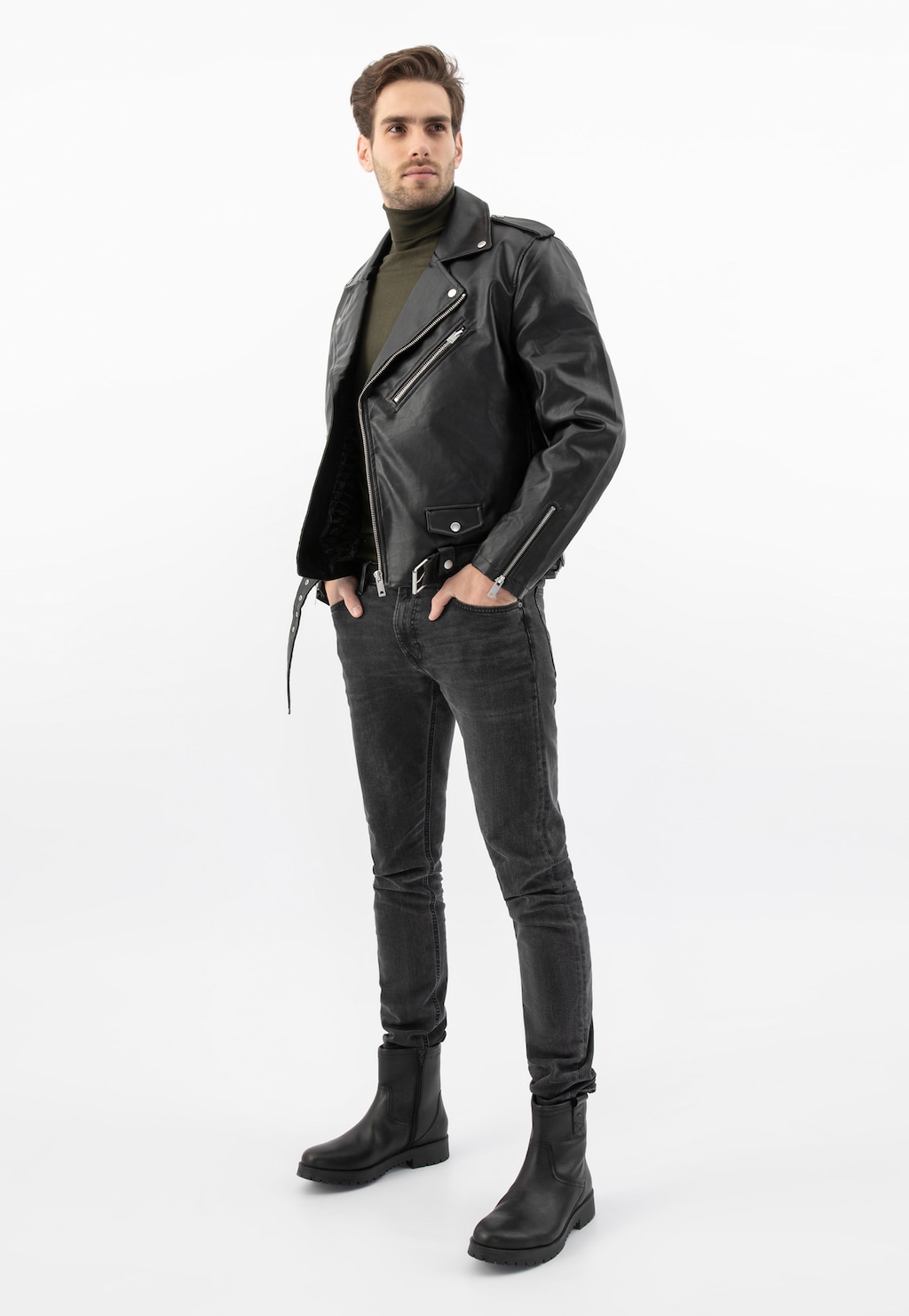 Model prezentujący czarne męskie botki Wojas 20028-51 zapinane na zamek. Stylizacja z czarną skórzaną kurtką, ciemnymi spodniami i oliwkowym golfem.