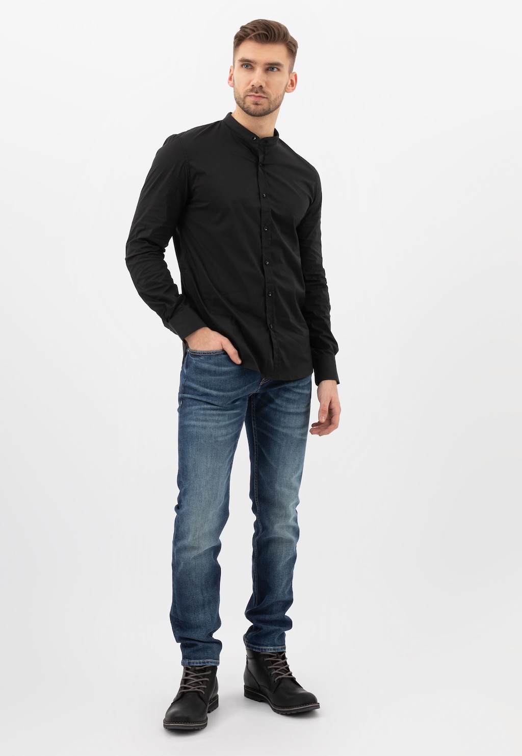 Model prezentujący czarne workery męskie Wojas 24031-71 z granatowymi akcentami, ubrany w czarną koszulę i niebieskie jeansy, w casualowej stylizacji.