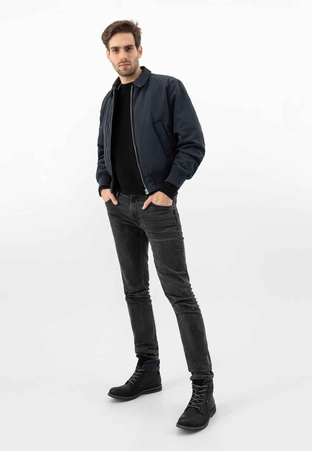 Model w ciemnej stylizacji prezentuje czarne workery męskie Wojas 24031-71 z granatowymi akcentami, zestawione z jeansami i granatową kurtką.