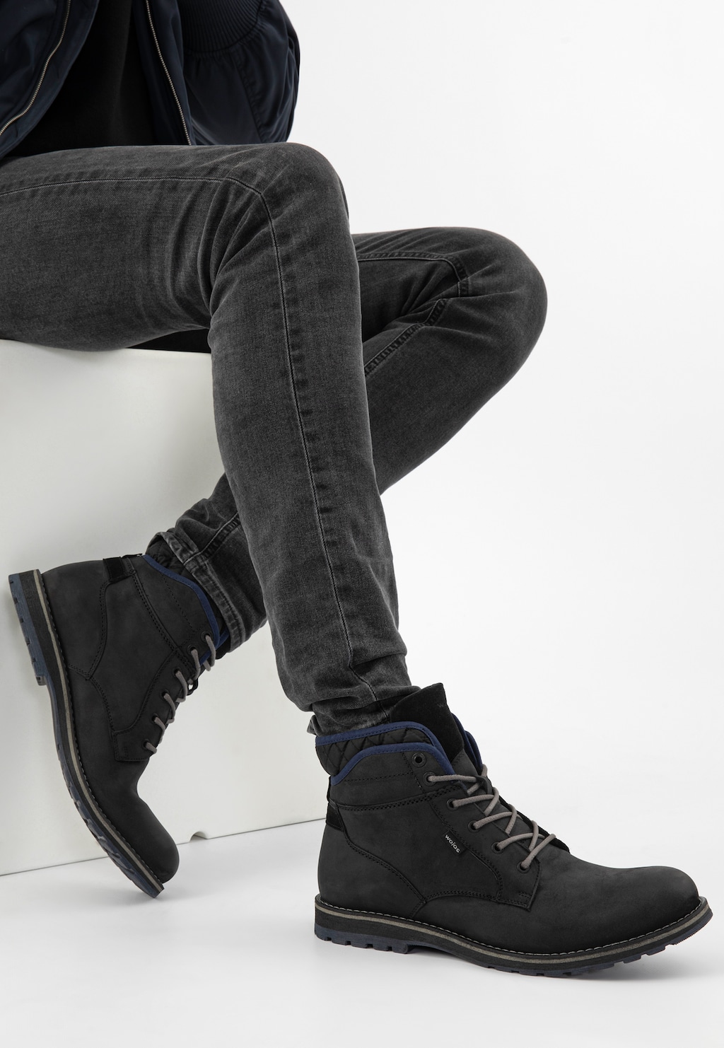 Czarne workery męskie Wojas 24031-71 z granatowymi akcentami na cholewce, prezentowane na nogach modela w ciemnych jeansach, widok z profilu.