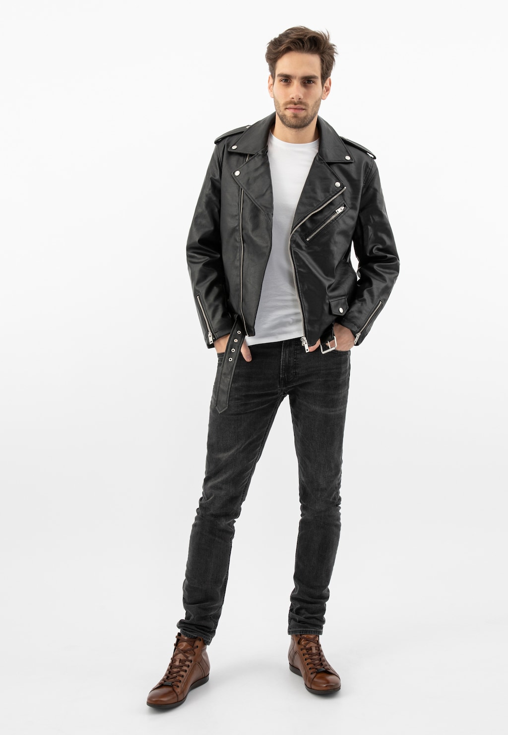 Model ubrany w stylizację z jasnobrązowymi trzewikami Wojas 24093-52 ze skóry licowej, czarną skórzaną kurtką i ciemnymi jeansami. Buty doskonale widoczne w całościowym outficie.