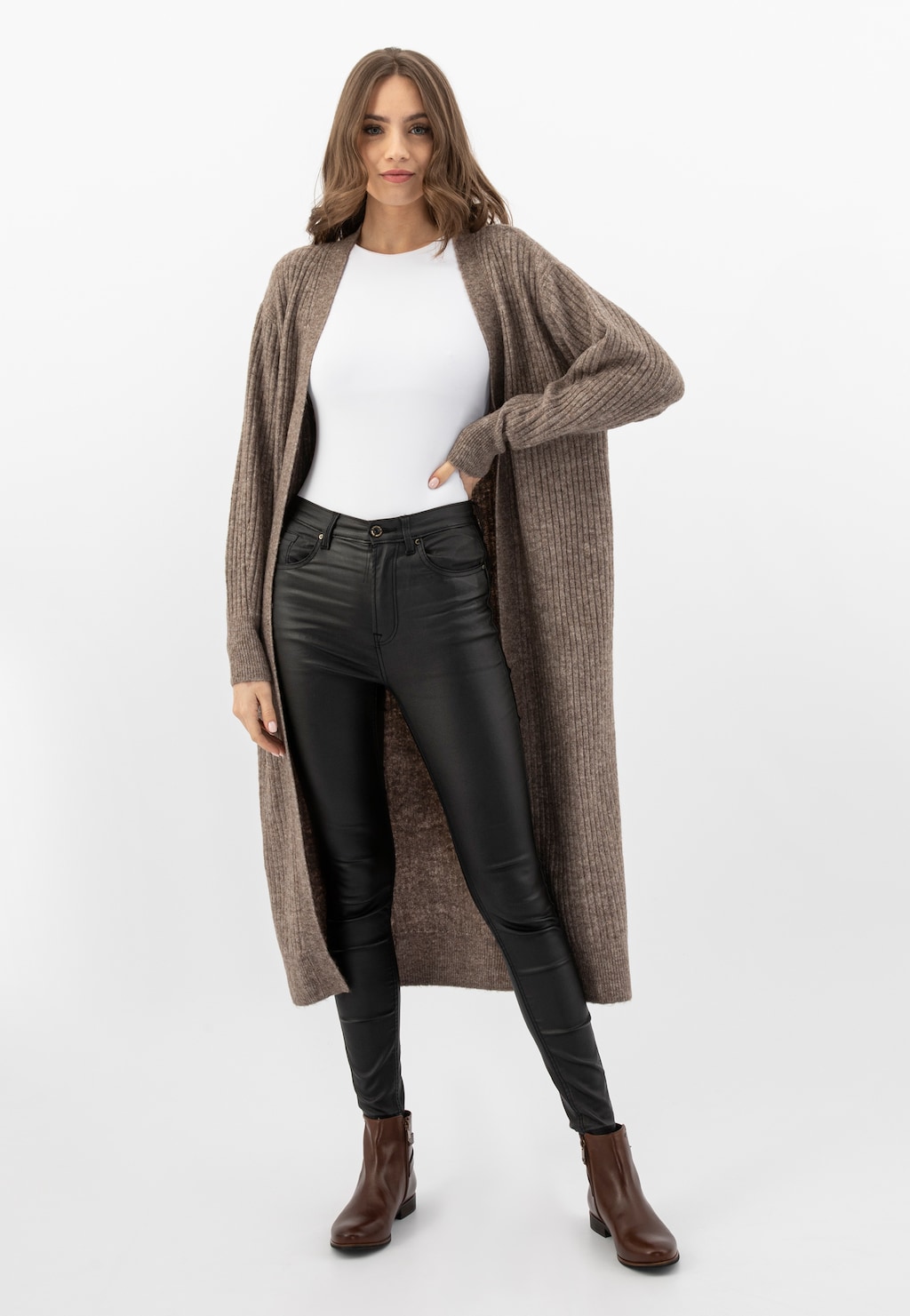 Modelka w jesiennej stylizacji z brązowymi botkami Wojas model 55066-50, długim beżowym kardiganem, białą bluzką i czarnymi spodniami. Botki na niskim obcasie z zamkiem.