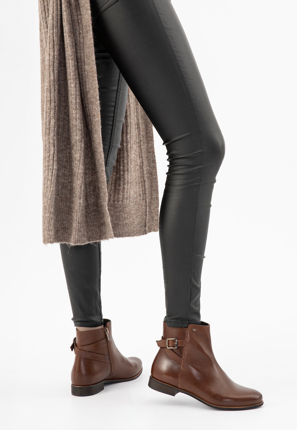 Brązowe botki damskie Wojas model 55066-50 z zamkiem i klamrą, noszone ze skórzanymi legginsami i beżowym swetrem. Eleganckie jesienne obuwie na płaskim obcasie.