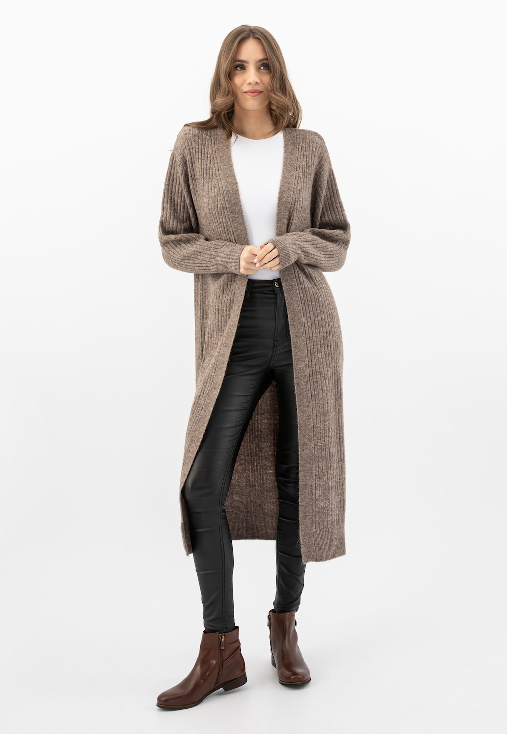 Modelka w długim beżowym kardiganie i czarnych spodniach, prezentująca brązowe botki damskie Wojas model 55066-50 na zamek, idealne na jesień.