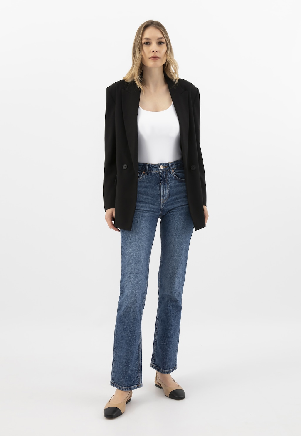 Elegancki outfit z dwukolorowymi balerinami Wojas 44032-54 z odkrytą piętą. Stylizacja z czarnym żakietem, białym topem i jeansami podkreśla uniwersalny charakter obuwia.