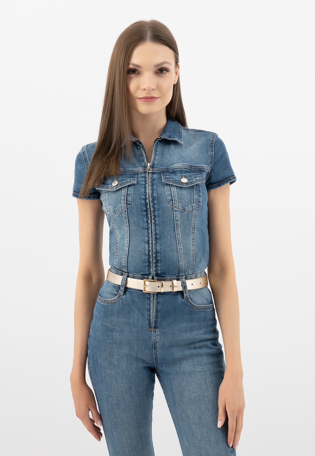 Modelka w jeansowym kombinezonie z krótkim rękawem, prezentująca złoty pasek damski Wojas ze skóry licowej model 9961-58, zapięty na talii.