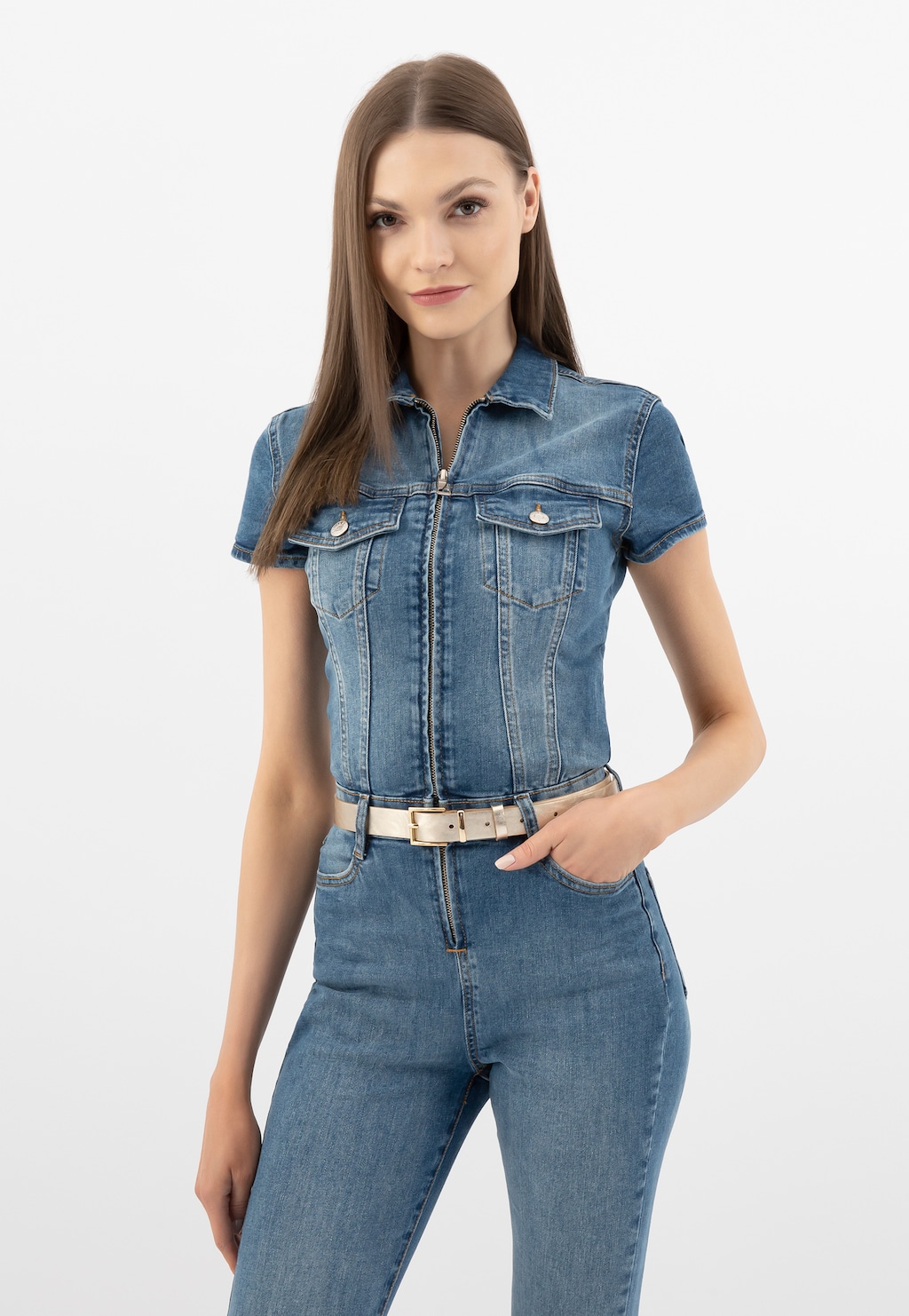 Modelka w jeansowym kombinezonie z krótkim rękawem, podkreślonym złotym paskiem damskim Wojas model 9961-58 ze skóry licowej. Elegancki dodatek do casualowej stylizacji.