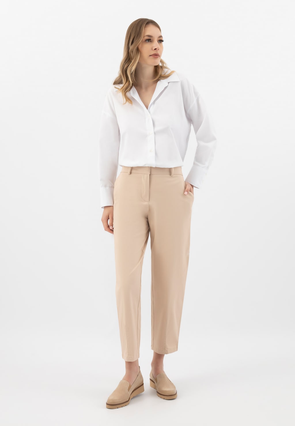 Elegancki strój biznesowy z beżowymi loafersami damskimi Wojas model 46008-74 na klinie, idealnie komponujący się z białą koszulą i beżowymi spodniami.