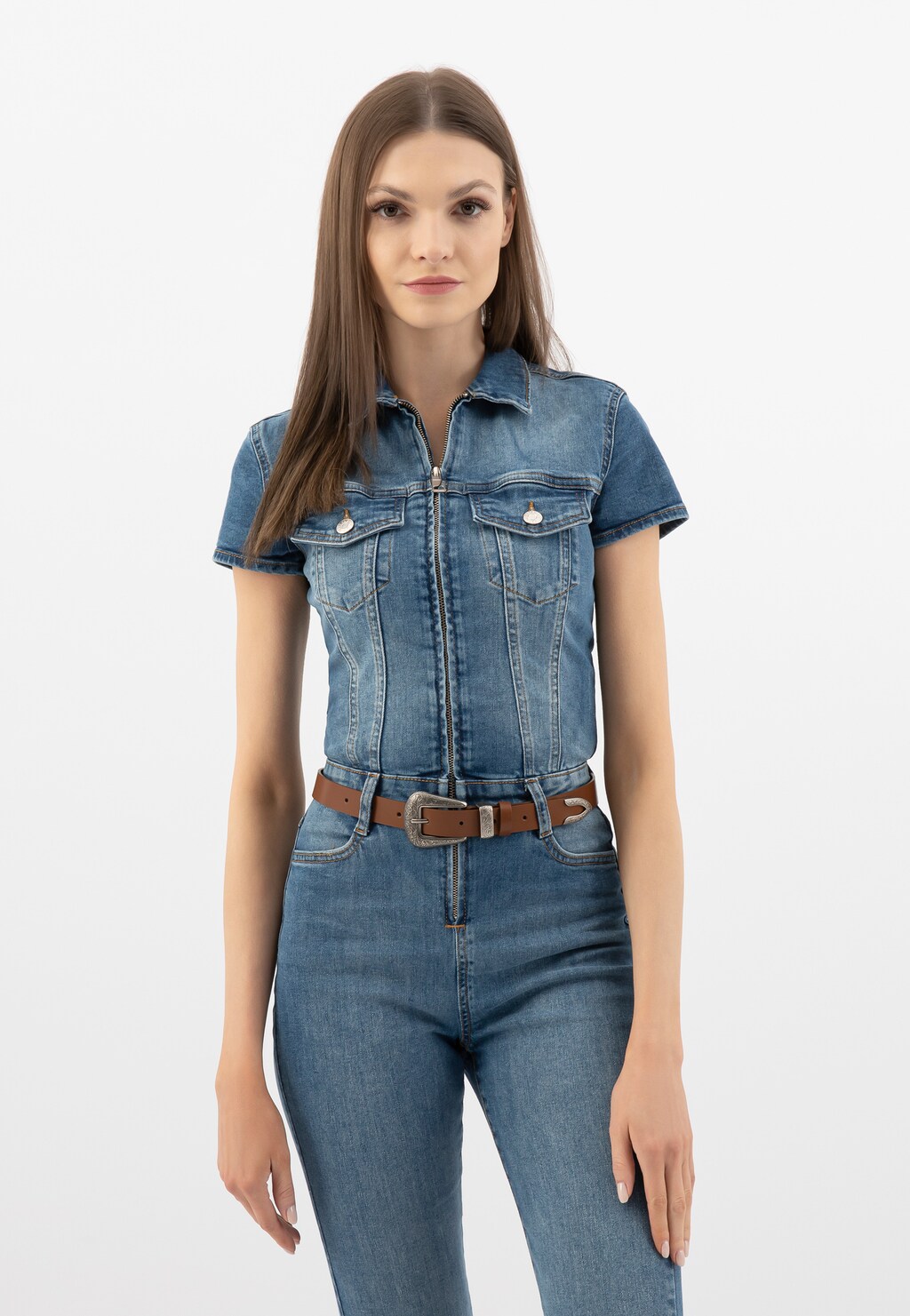 Stylizacja z jeansowym kombinezonem, wyeksponowany brązowy pasek Wojas model 93012-52 z ozdobnym tłoczeniem na klamrze, dopełniający modny dżinsowy outfit.