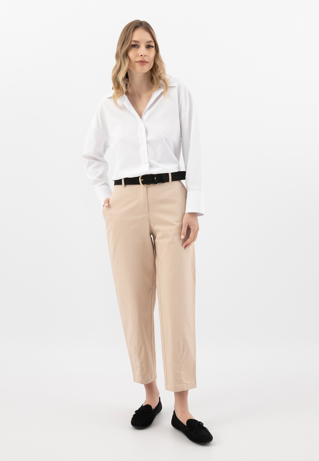 Stylizacja z czarnym paskiem damskim Wojas 93088-21 ze złotą klamrą, białą koszulą, beżowymi spodniami i czarnymi butami. Elegancki, biznesowy look.
