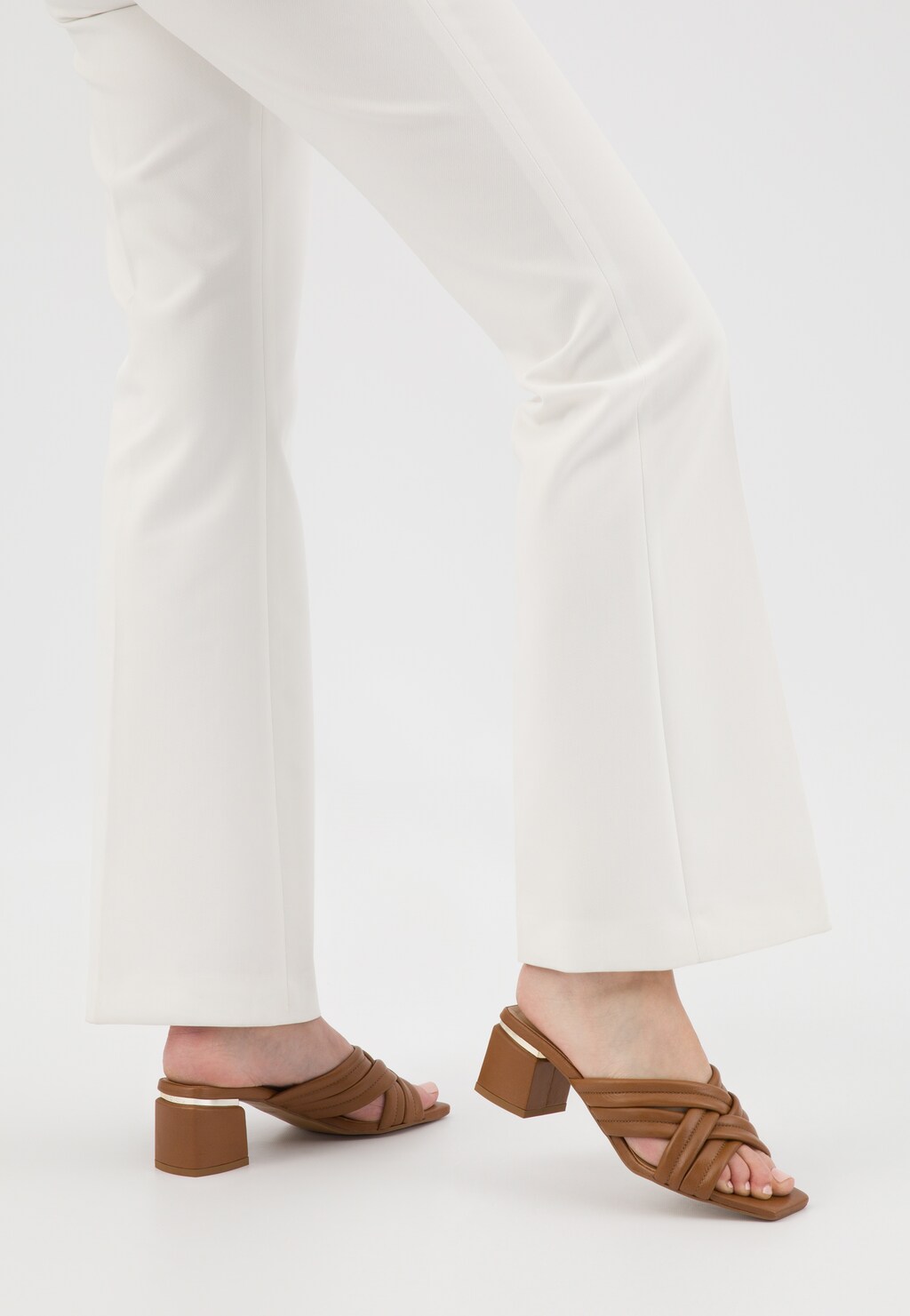 Jasnobrązowe klapki Wojas 74072-54 z eleganckimi przeplatanymi paskami na stabilnym obcasie, prezentowane na modelu w białych spodniach.