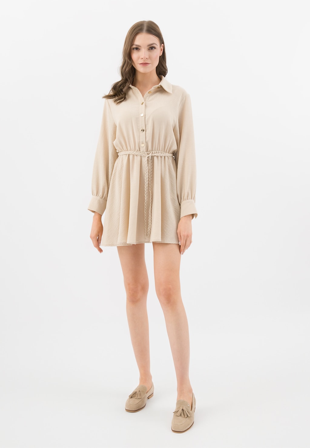 Modelka w beżowej sukience koszulowej z przewiązaniem w talii, prezentująca beżowe lordsy Wojas model 46272-64 z ozdobnymi chwostami, idealne do eleganckiej stylizacji.